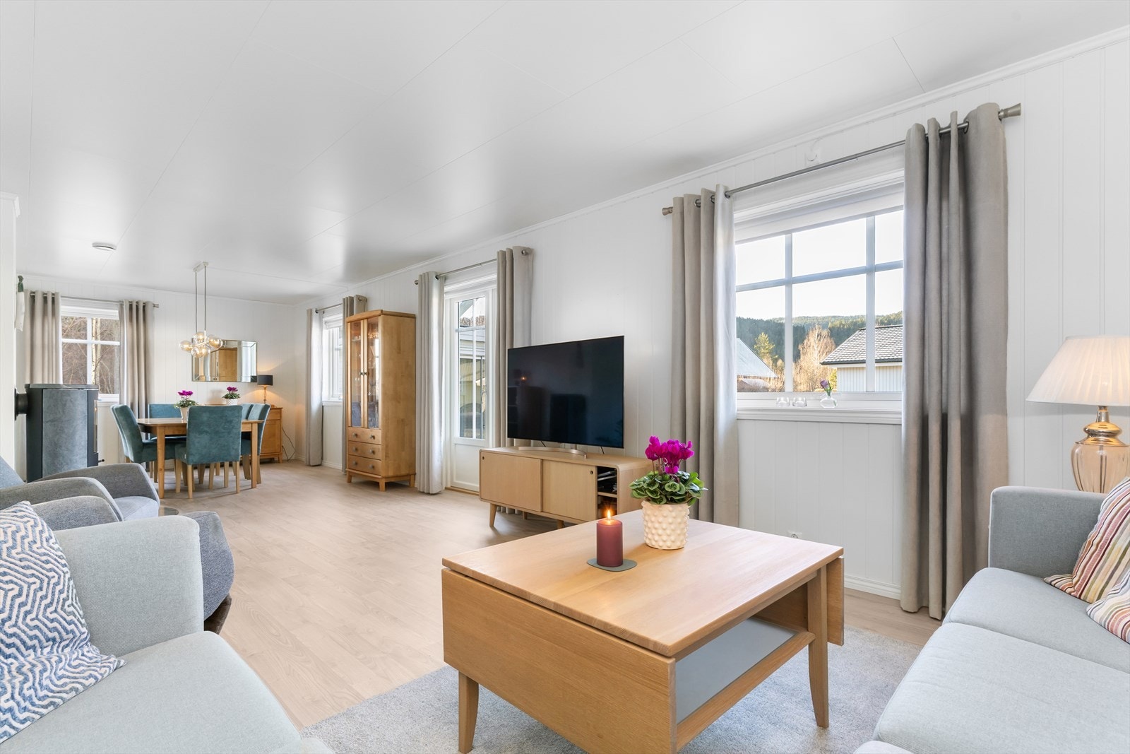 Romslig stue- og spisestue med utgang til terrasse, hage og hagestue. Galleribilde