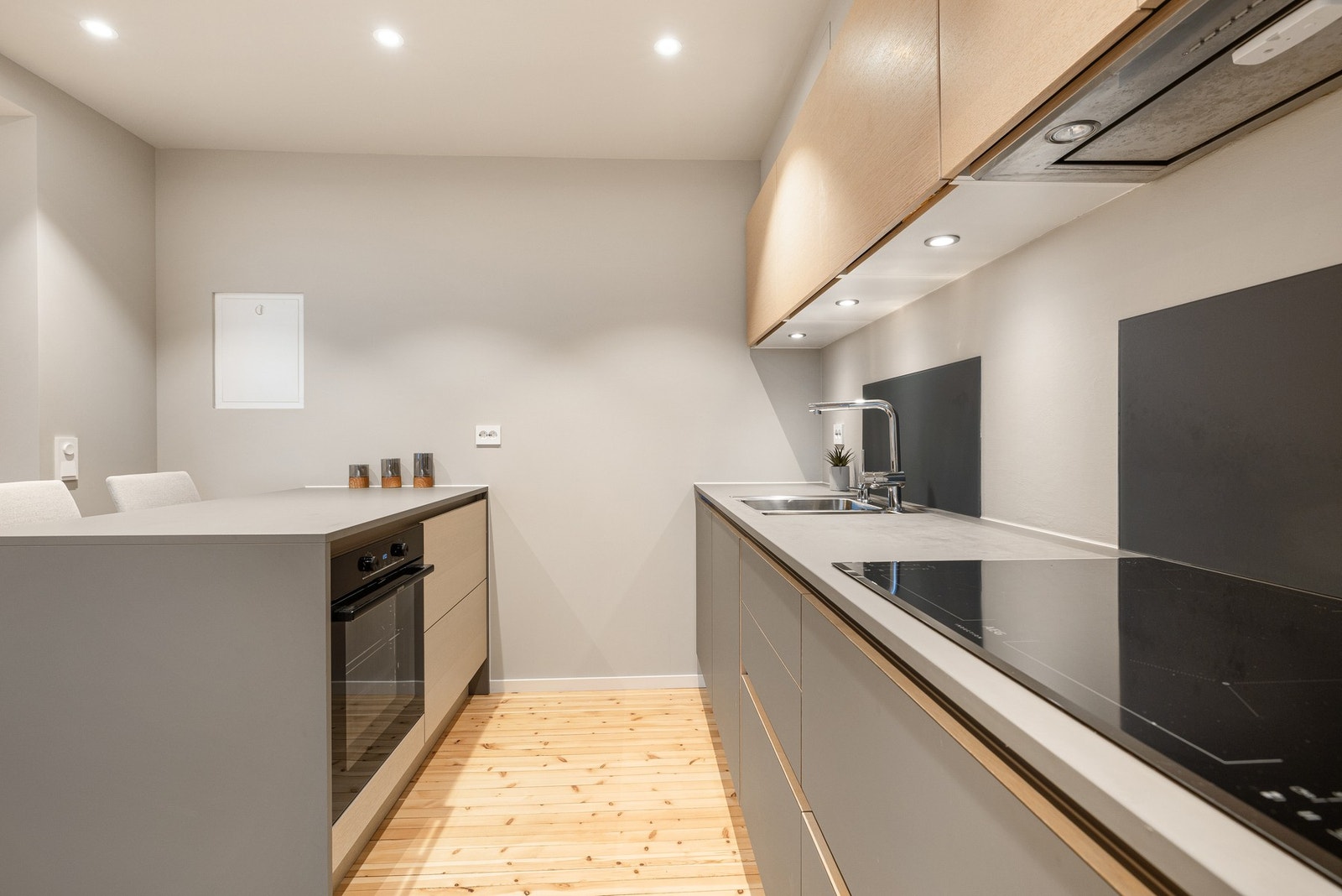 Kjøkkenet har delvis integrerte hvitevarer og kjøkkenventilator med avtrekk ut Galleribilde