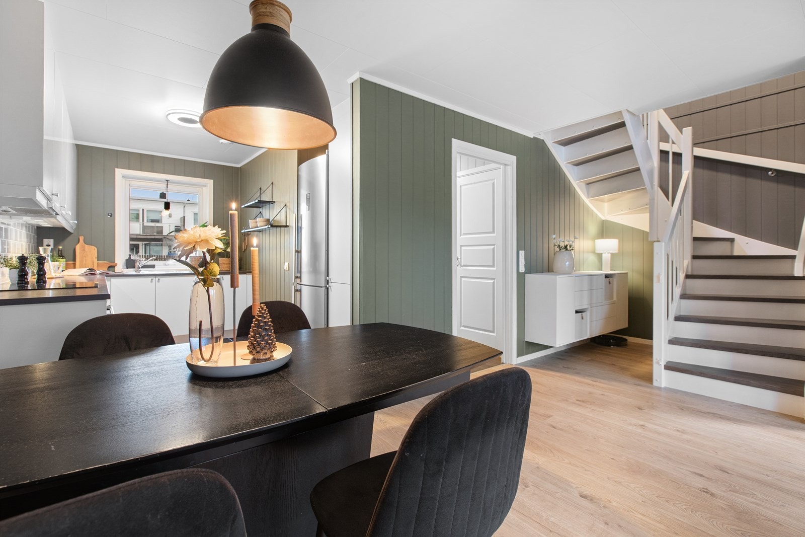 Den lukkede tretrappen med mørke trinn og hvitt rekkverk fører opp til boligens andre etasje. Galleribilde