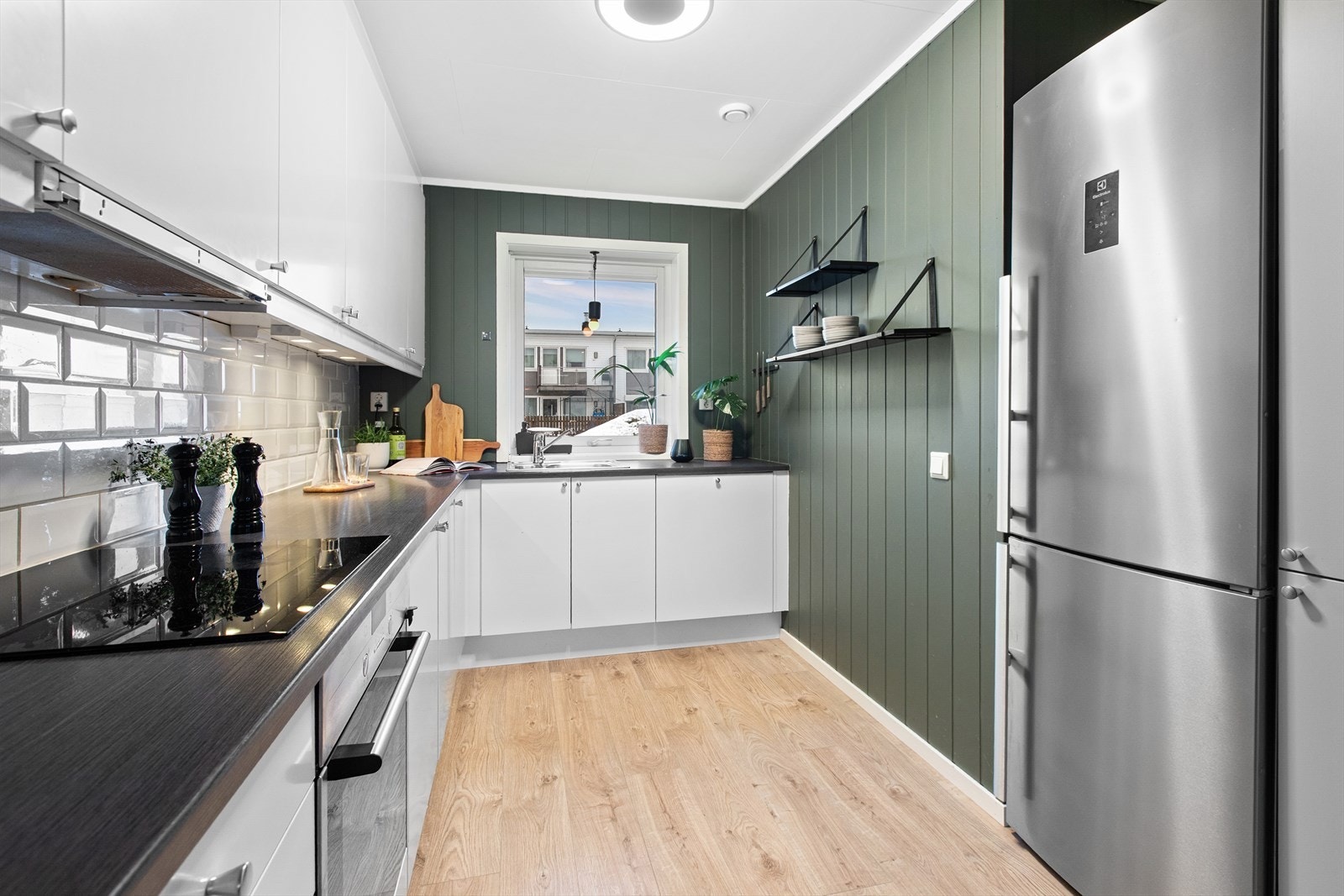 Moderne kjøkkeninnredning fra Sigdal med glatte, hvite fronter og mørk laminatbenkeplate. Galleribilde