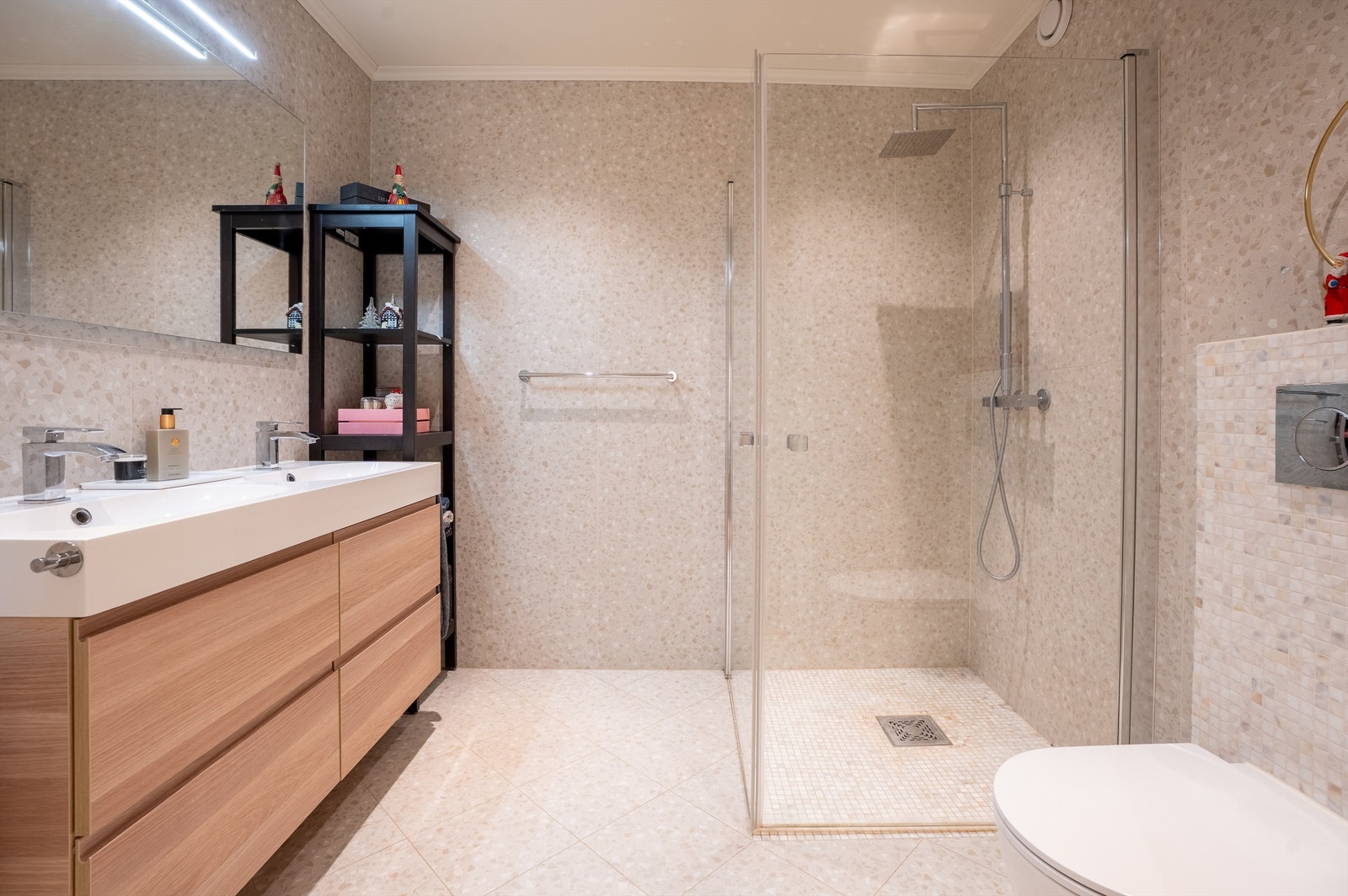 Badet er helfliset med varmekabler i gulvet, to servanter, vegghengt toalett og dusjhjørne. Dette er badet til hybelleiligheten. Galleribilde