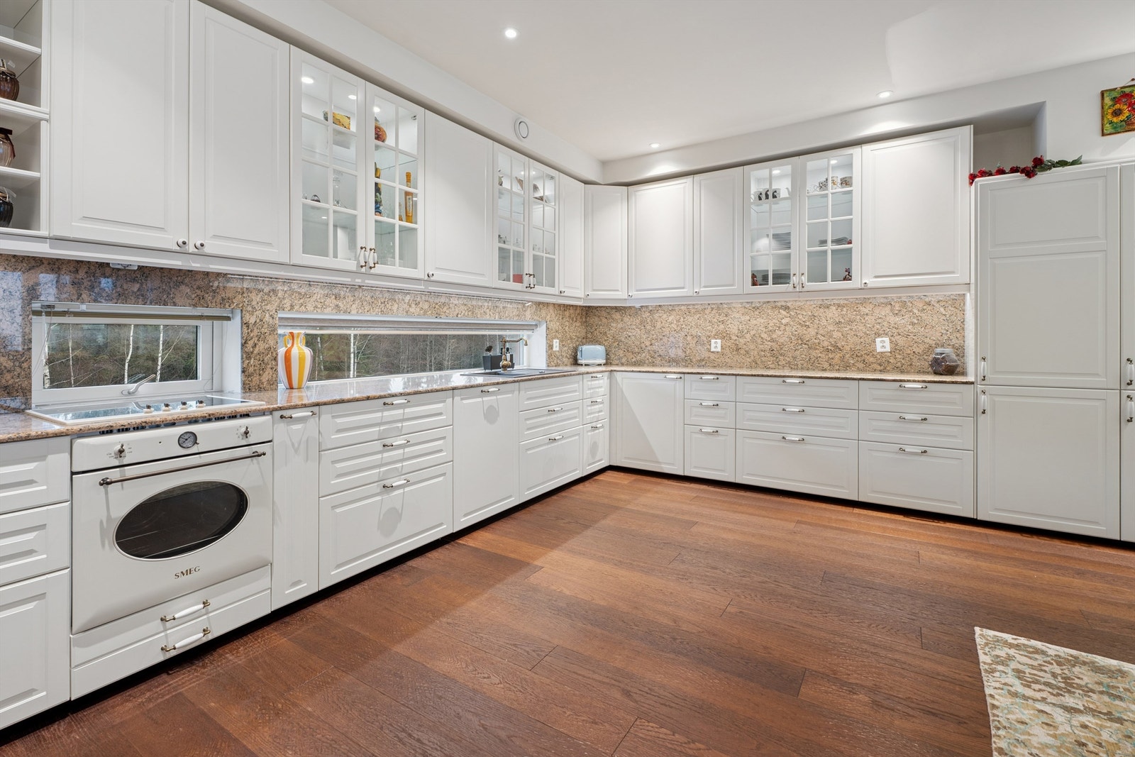 Kjøkkenet har en takhøy innredning med profilerte fronter og vitrineskap. Galleribilde