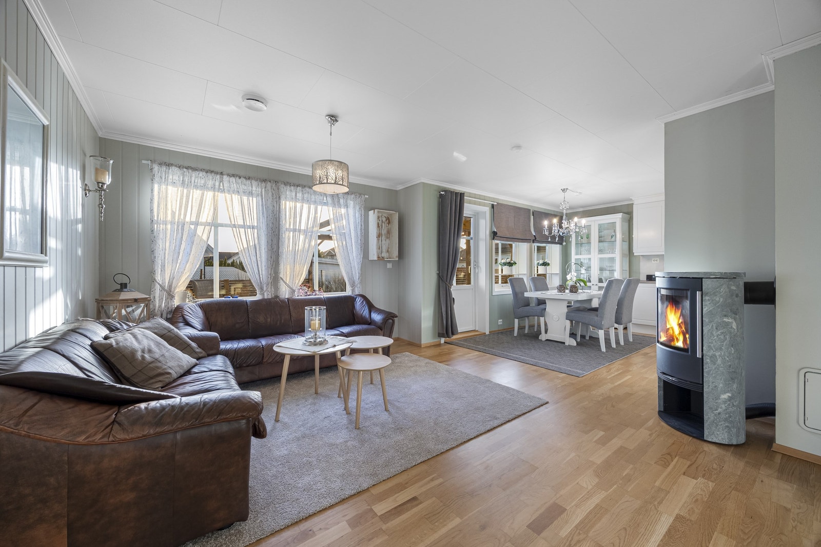 Stue med peisovn og lyse flater. Parkett på gulv. Galleribilde