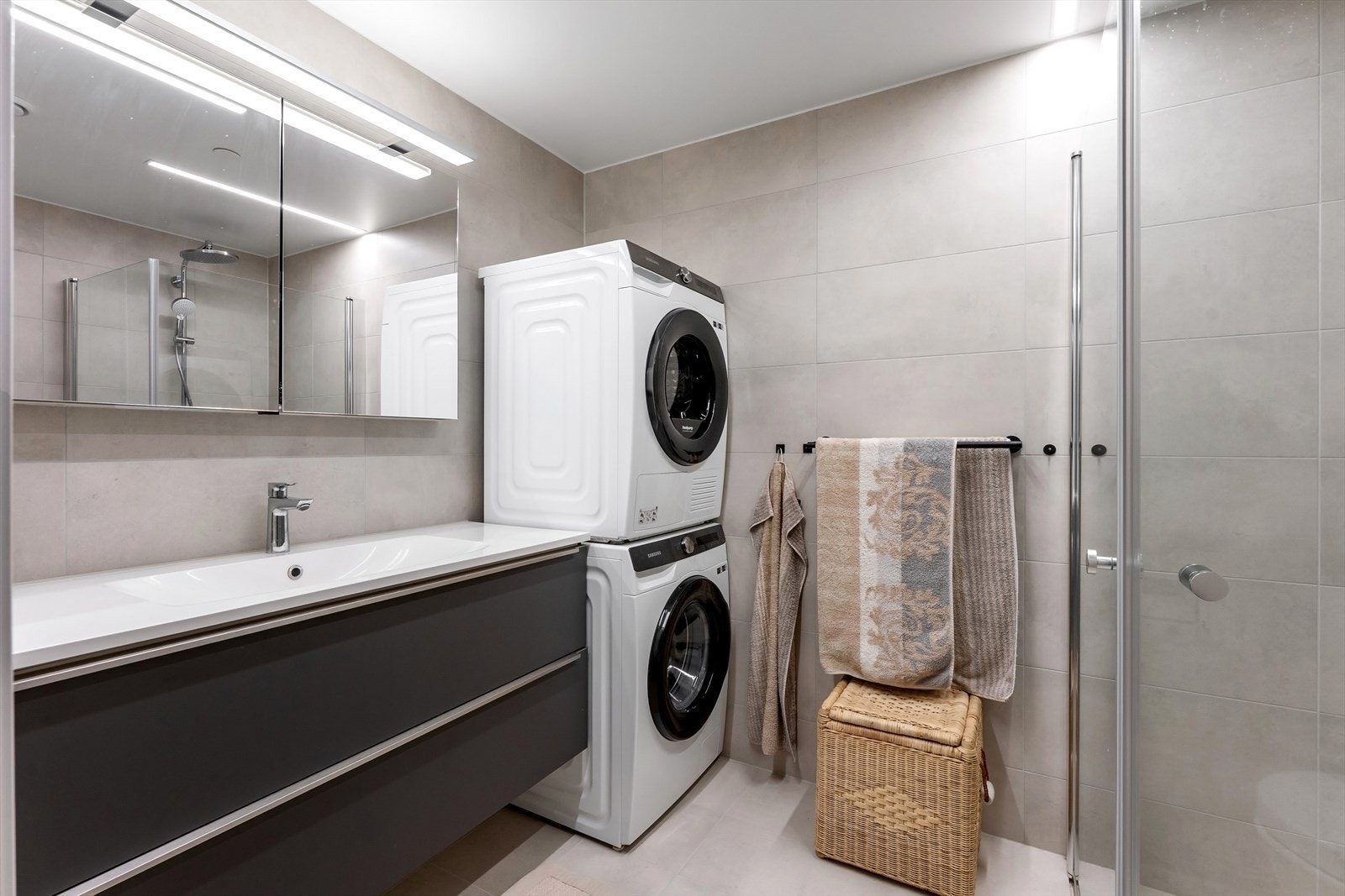 Badet er innredet med skuffeinnredning, servant med ettgreps armatur og speilskap med LED-list. Galleribilde