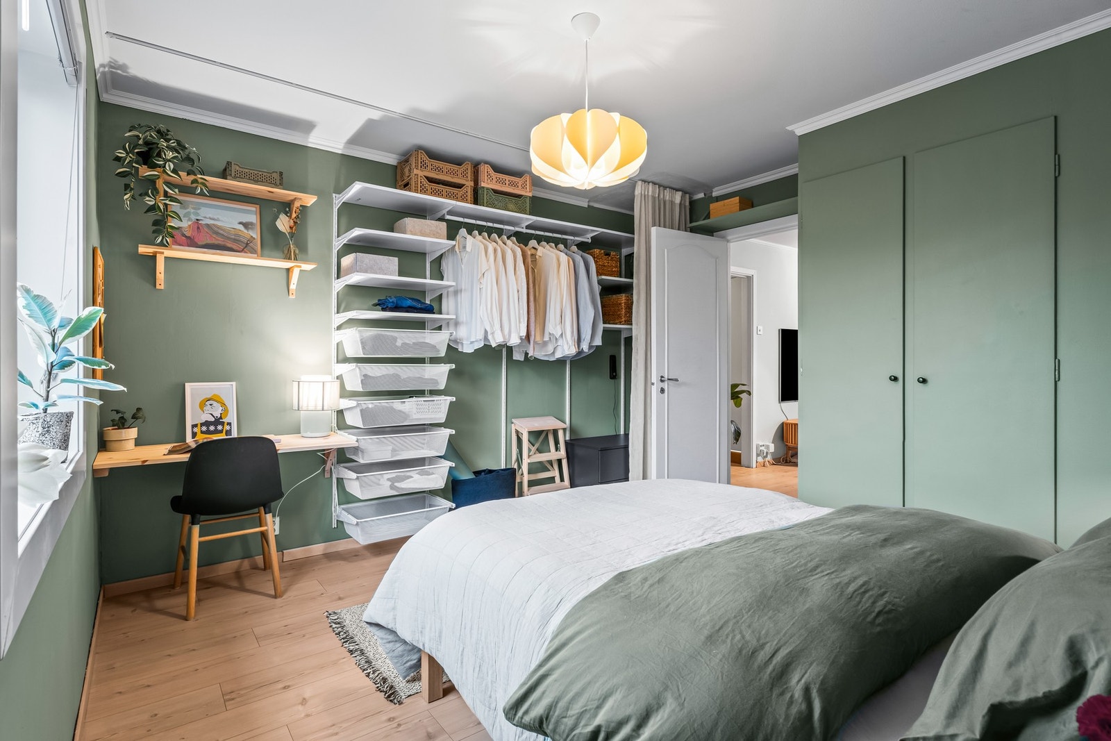 Videre har rommet også en åpen garderobeløsning med skuffer, hyller og klesoppheng. Galleribilde