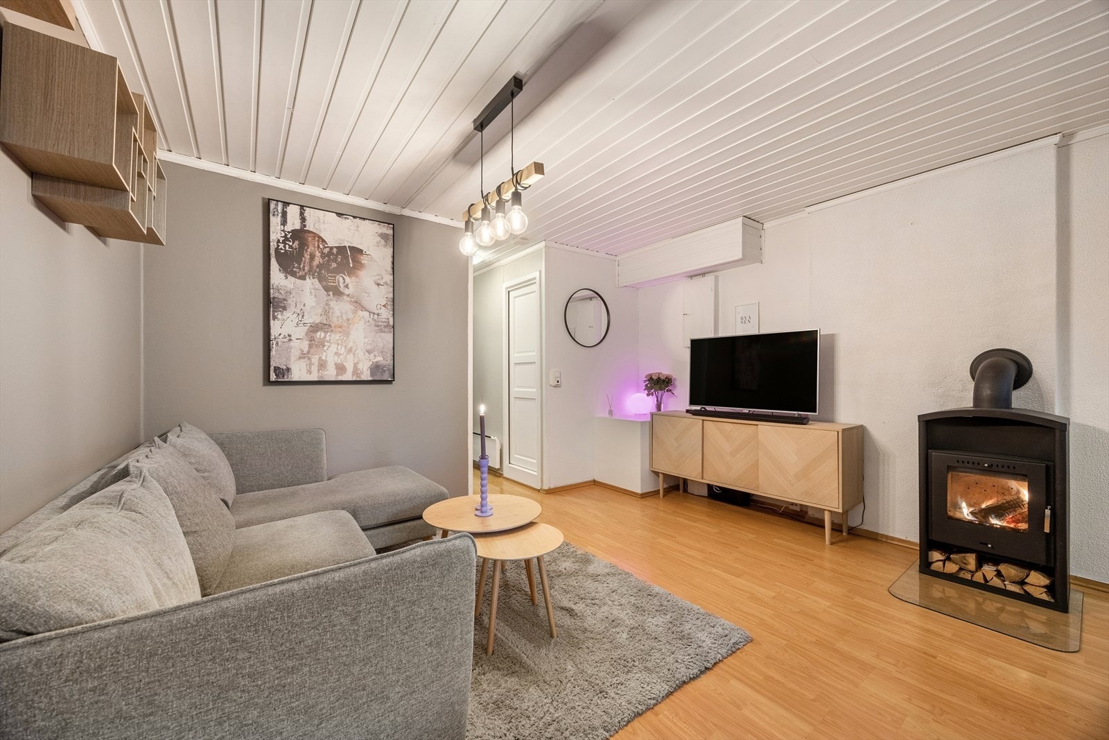 Rommet har en smart utforming som enkelt rommer både en stor sofagruppe, TV-seksjon, og en koselig spisestue. Galleribilde