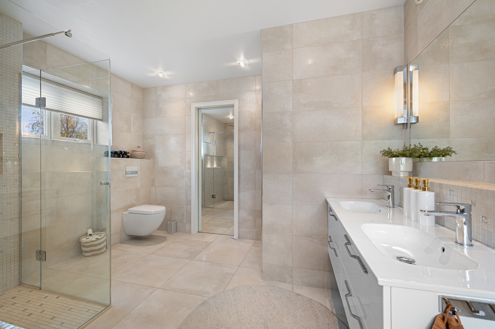 Baderommet er flislagt og har dobbel servant, dusjsone og vegghengt toalett. Galleribilde