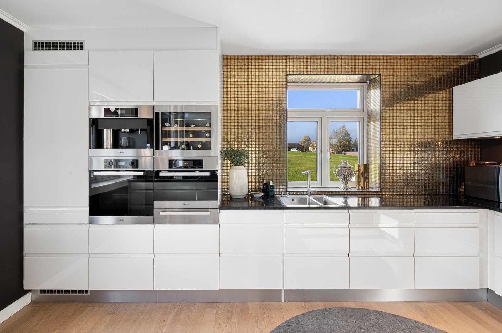 Stilrent kjøkken med integrerte hvitevarer og vinskap som gir det lille ekstra. Galleribilde