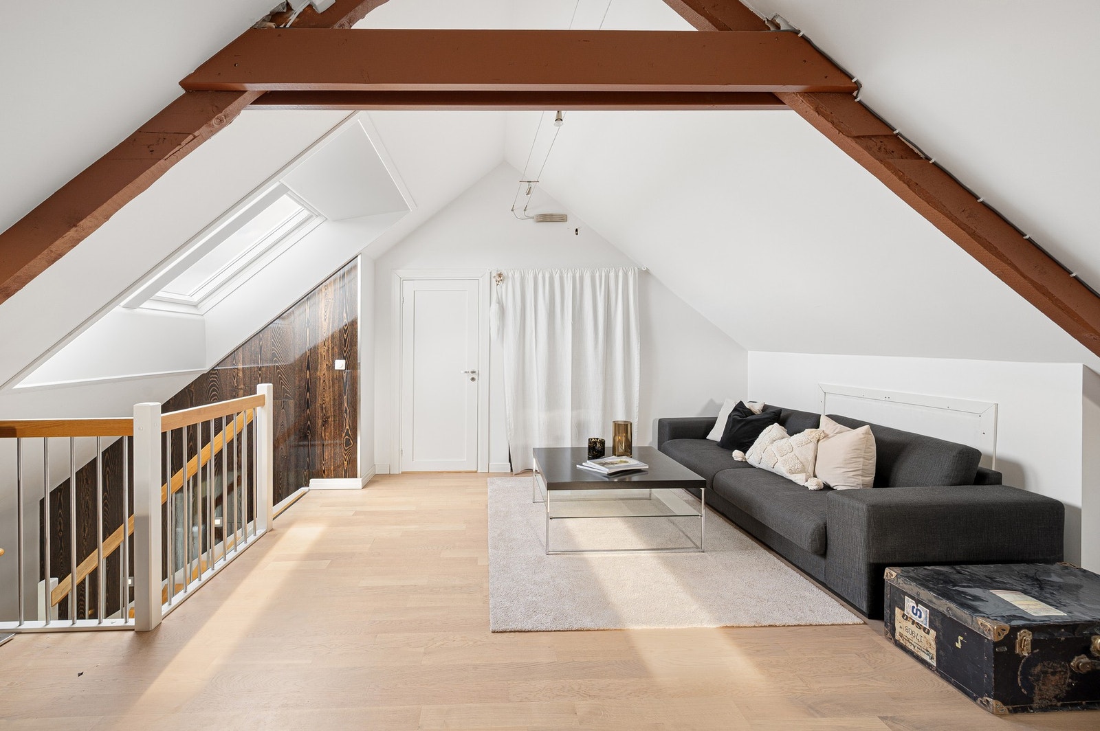 Lys loftsstue med god takhøyde og synlige bjelker som gir rommet karakter og særpreg. Galleribilde