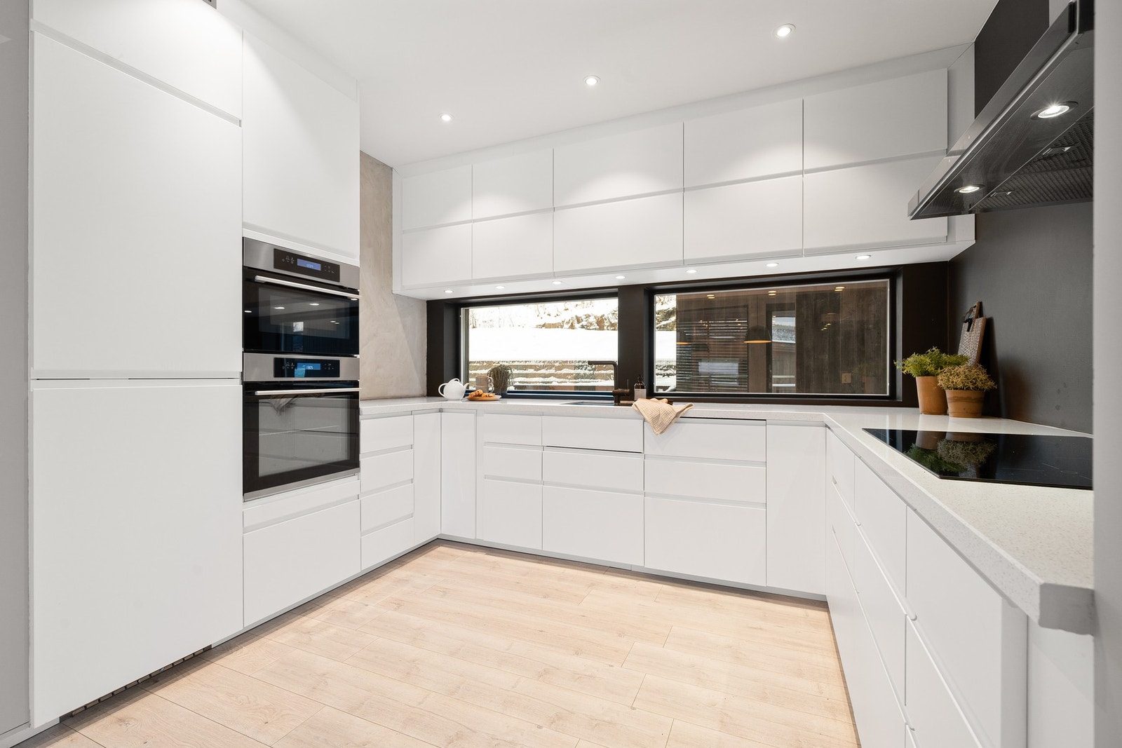 Stilren innredning fra IKEA med takhøye overskap, slette fronter og benkeplate i komposittmateriale Galleribilde