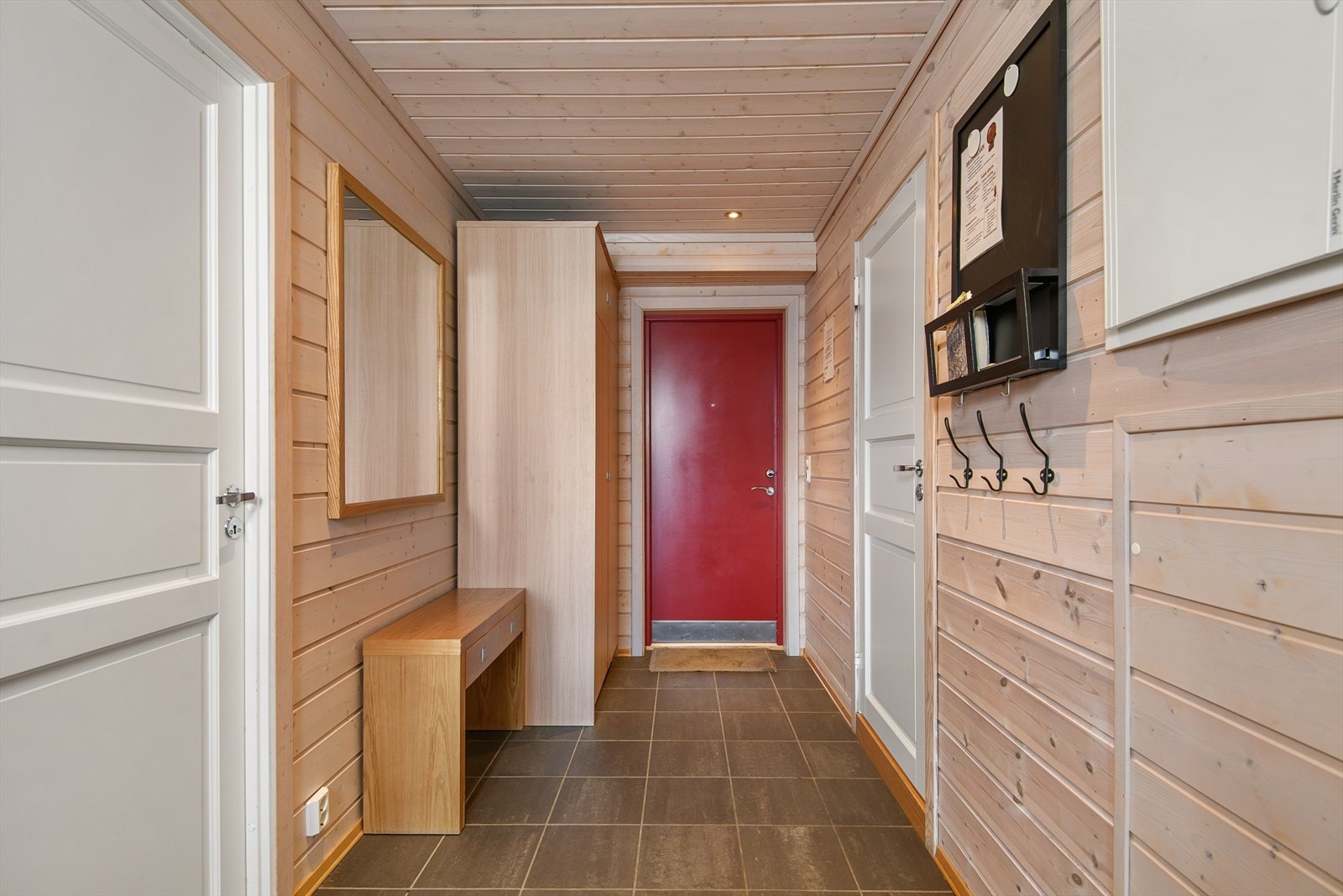 Gang med flislagt gulv og muligheter til å henge fra seg yttertøyet. Galleribilde