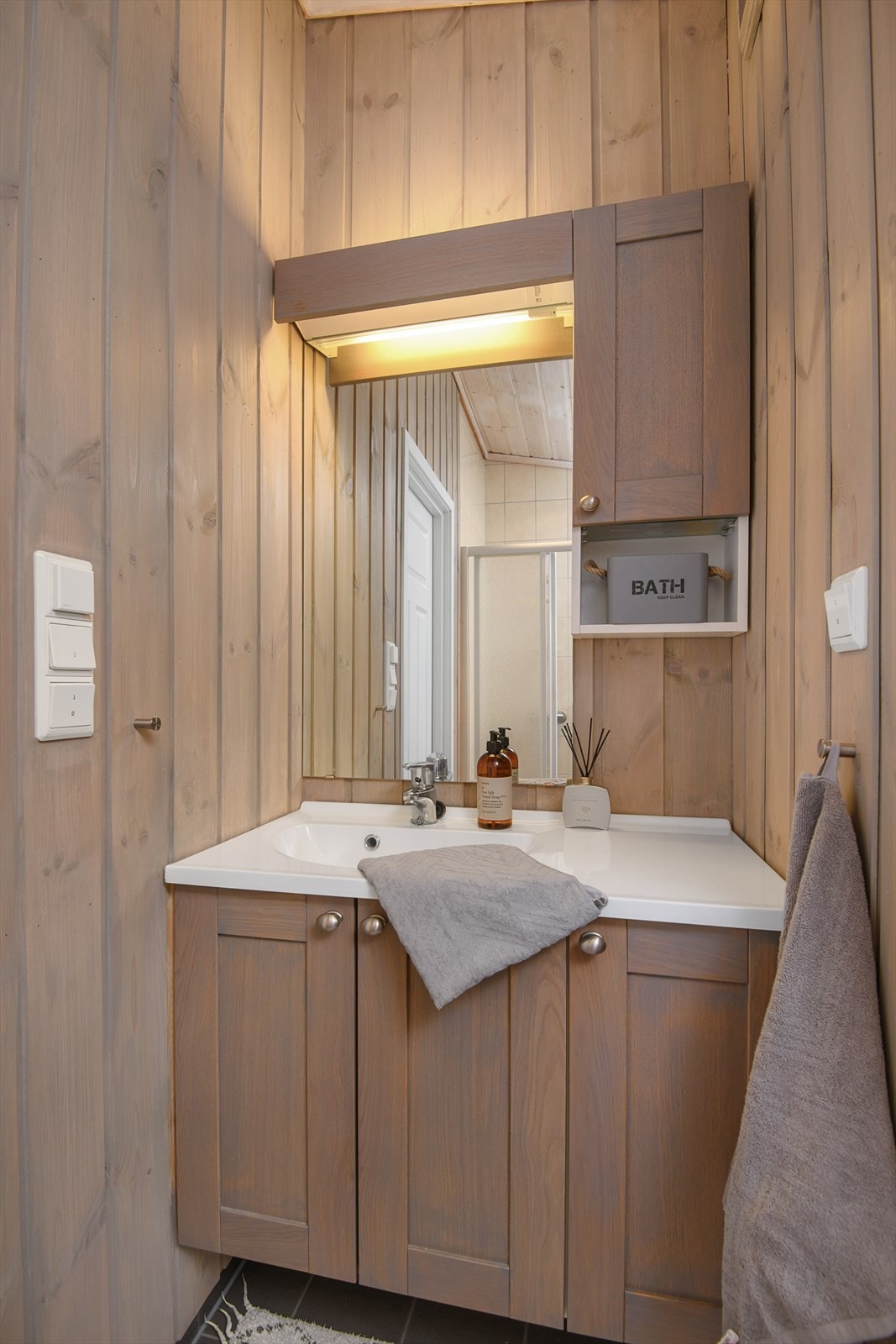 Servantinnredning med skap for oppbevaring. Frontene er beiset i matchende fargetone til veggene. Galleribilde