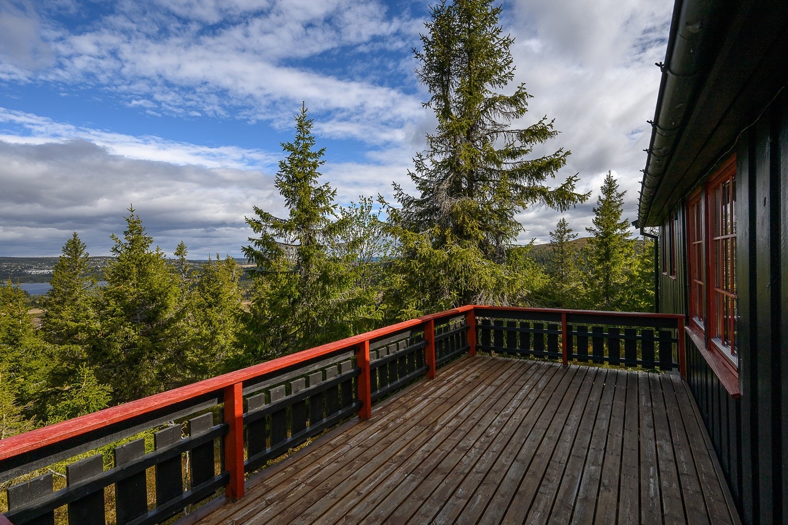 Det er en romslig og åpen terrasse på hytta. Her sitter du i fred og ro i relativt usjenerte omgivelser. Utsikt retning Sjusjøen. Galleribilde