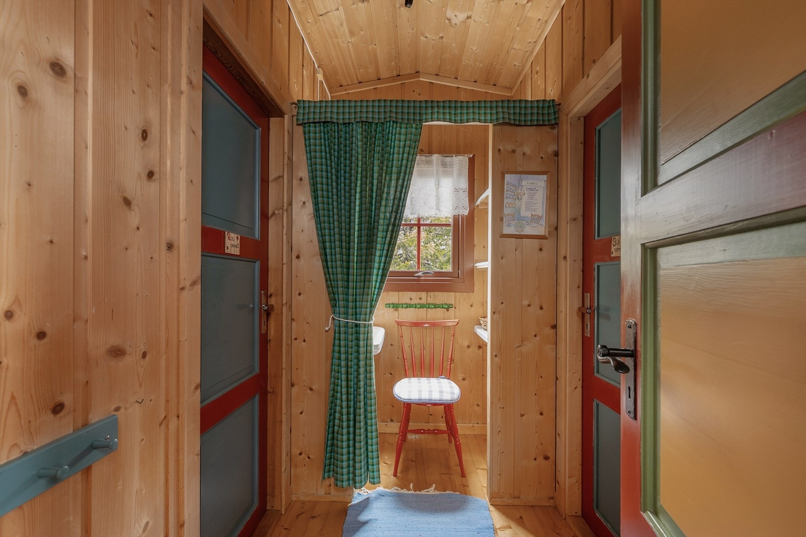 Det er en liten gang innenfor kjøkkenet med adkomst til 2 av soverommene i hytta. Malte innerdører. Galleribilde