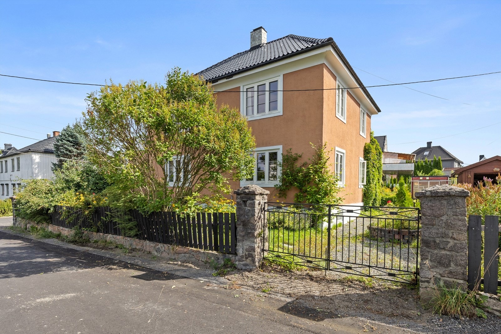 Tomten er inngjerdet og har smijernsporter Galleribilde