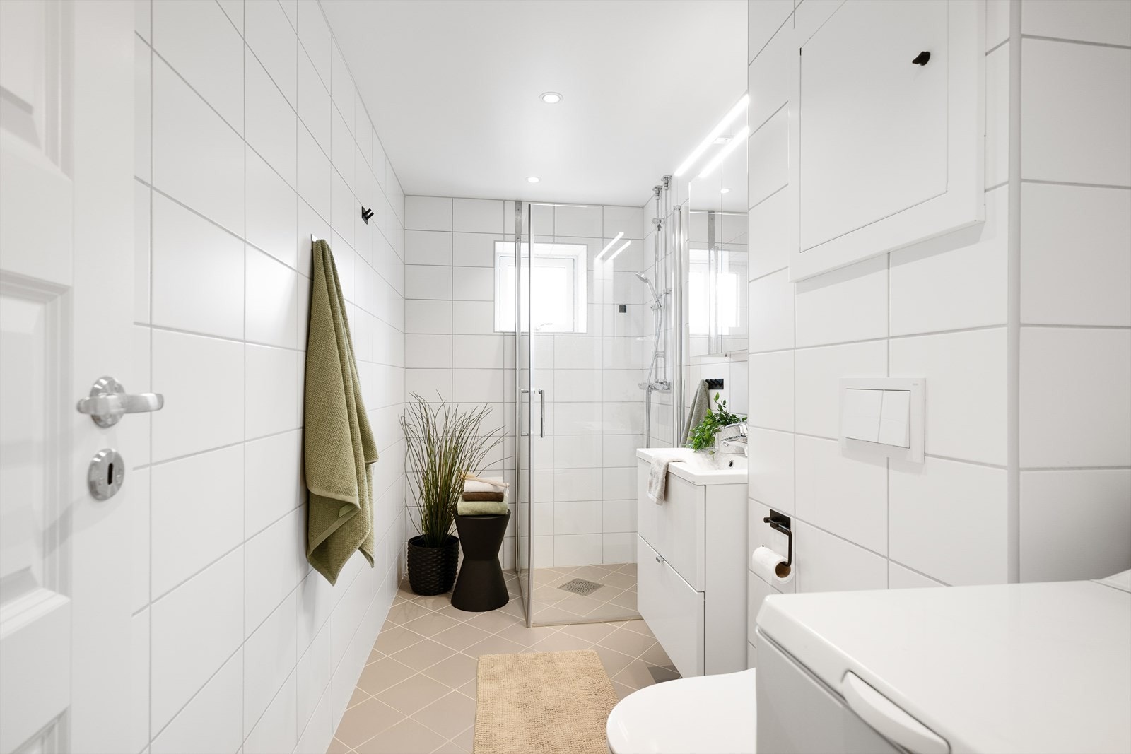 Stilrent og pent bad med tidløse fargetoner! Fliser på vegg og gulv med varmekabler og opplegg for vaskemaskin. Galleribilde