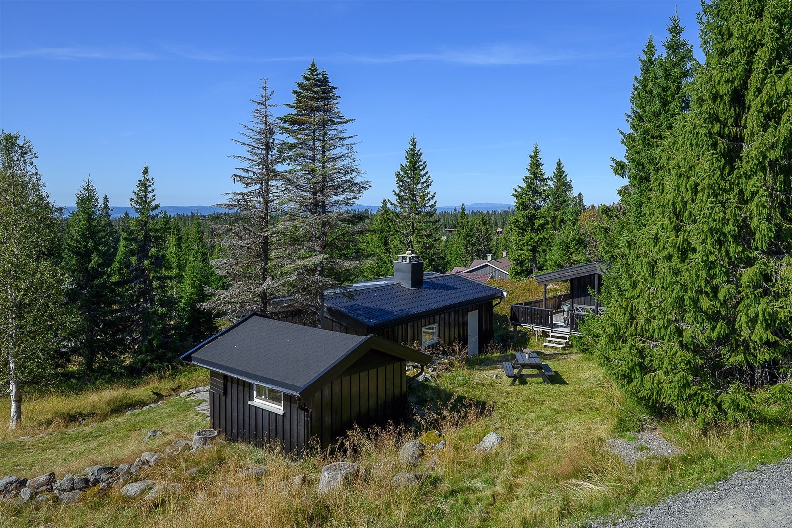 Lett skrånende tomt der du er forholdsvis skjermet for direkte innsyn på uteplassene ved hytta. Galleribilde