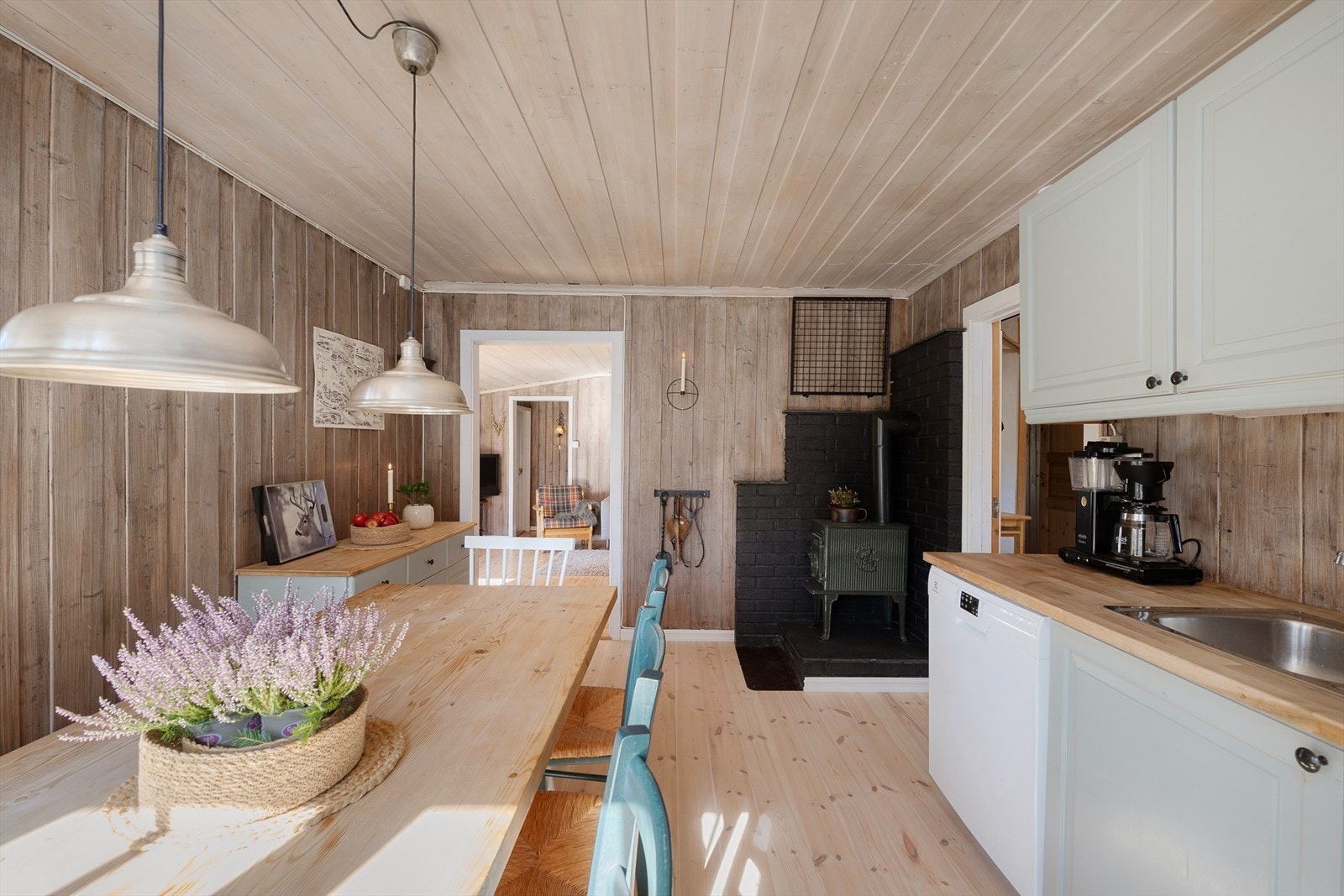 Koselig kjøkken med beiset panel på veggene og tregulv. Vedovn for god oppvarming. Galleribilde