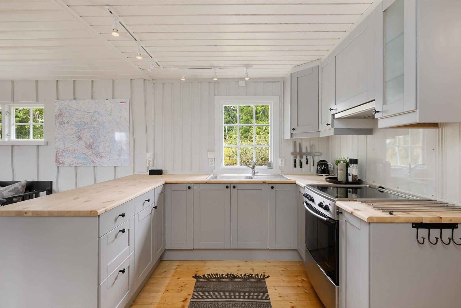 Pent og praktisk kjøkken i U-form med fronter som er malt i en lun, delikat og tidløs gråtone. Galleribilde