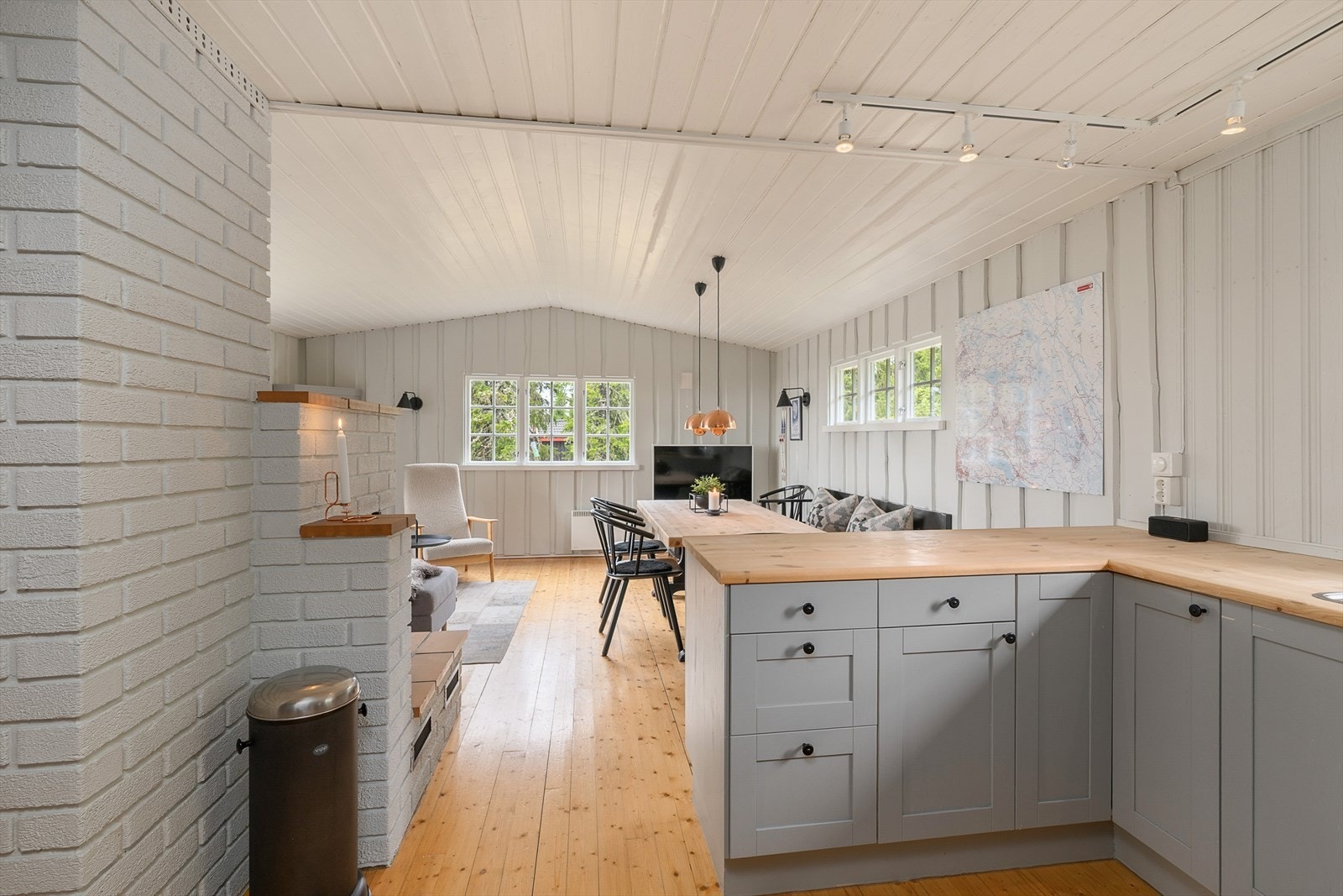 Lett profilering på frontene. Trehvit benkeplate. Fin kontakt mellom kjøkken og spiseplass. Galleribilde