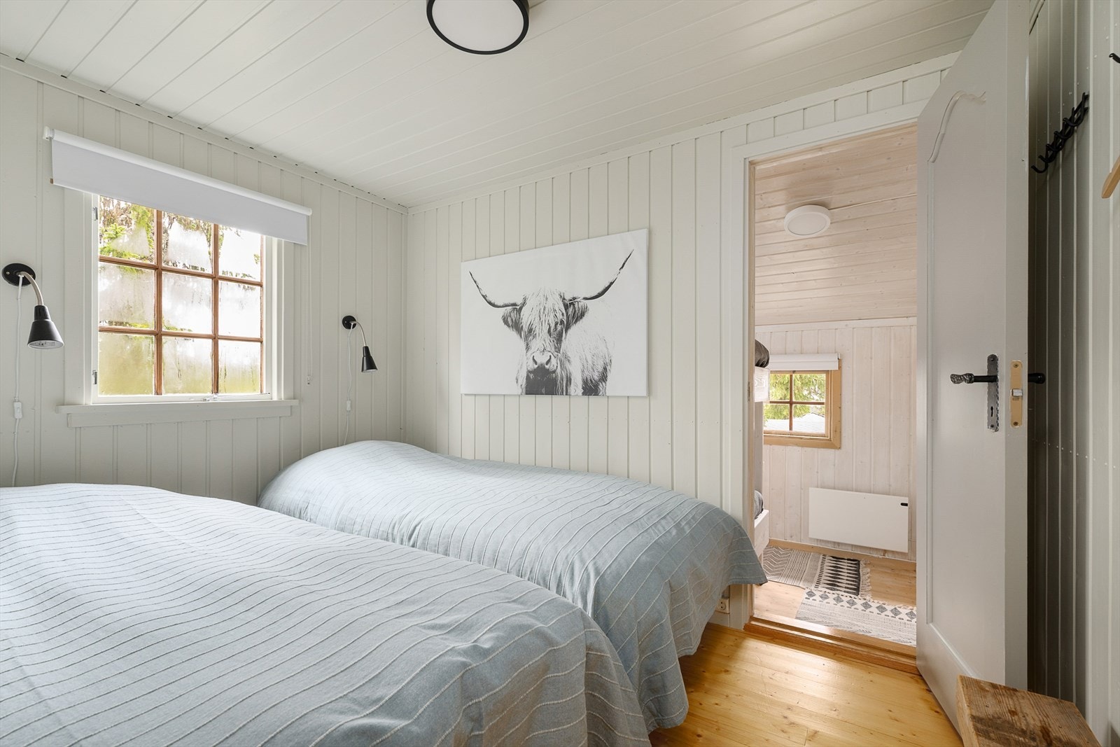 Hytta har 2 soverom med dør i mellom. Soverom 1 innredet med 2 senger. Lyst og tiltalende med malt panel på tak og vegger. Galleribilde
