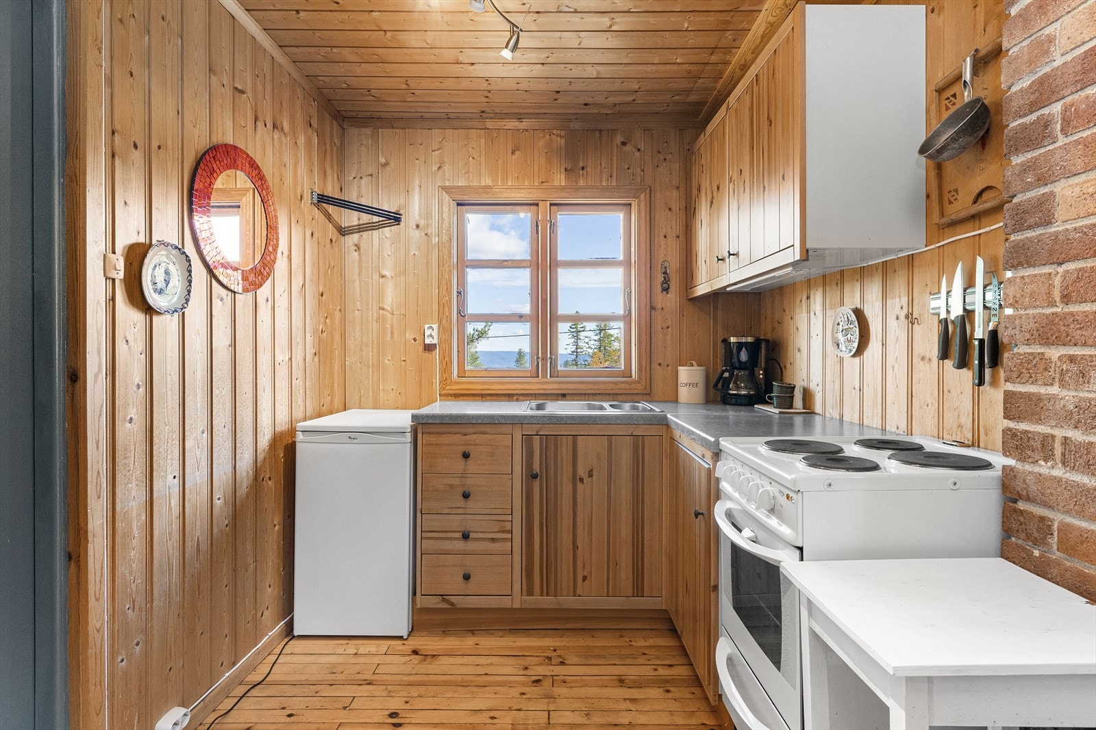 Lyst og koselig kjøkken med vindu over benken og god arbeidsflate. Galleribilde