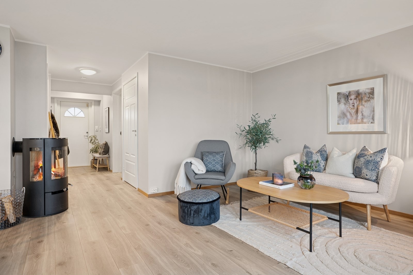 Stuen har naturlige soner for både sofagruppe og spisestue, og den stemningsfulle peisovnen fungerer som et naturlig midtpunkt i rommet Galleribilde