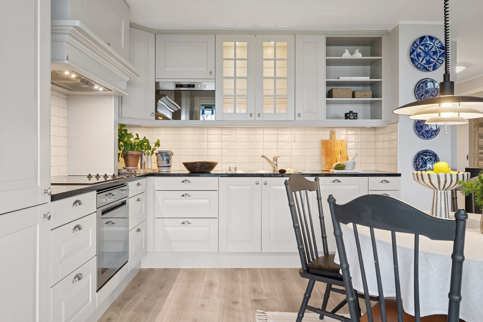 Kjøkkenet er utstyrt med oppvaskkum og kjøkkenvifte med mekanisk avtrekk, samt hvitevarer som inkluderer platetopp, komfyr, oppvaskmaskin, mikrobølgeovn og kjøl/frys - alt tilpasset for et moderne uttrykk Galleribilde