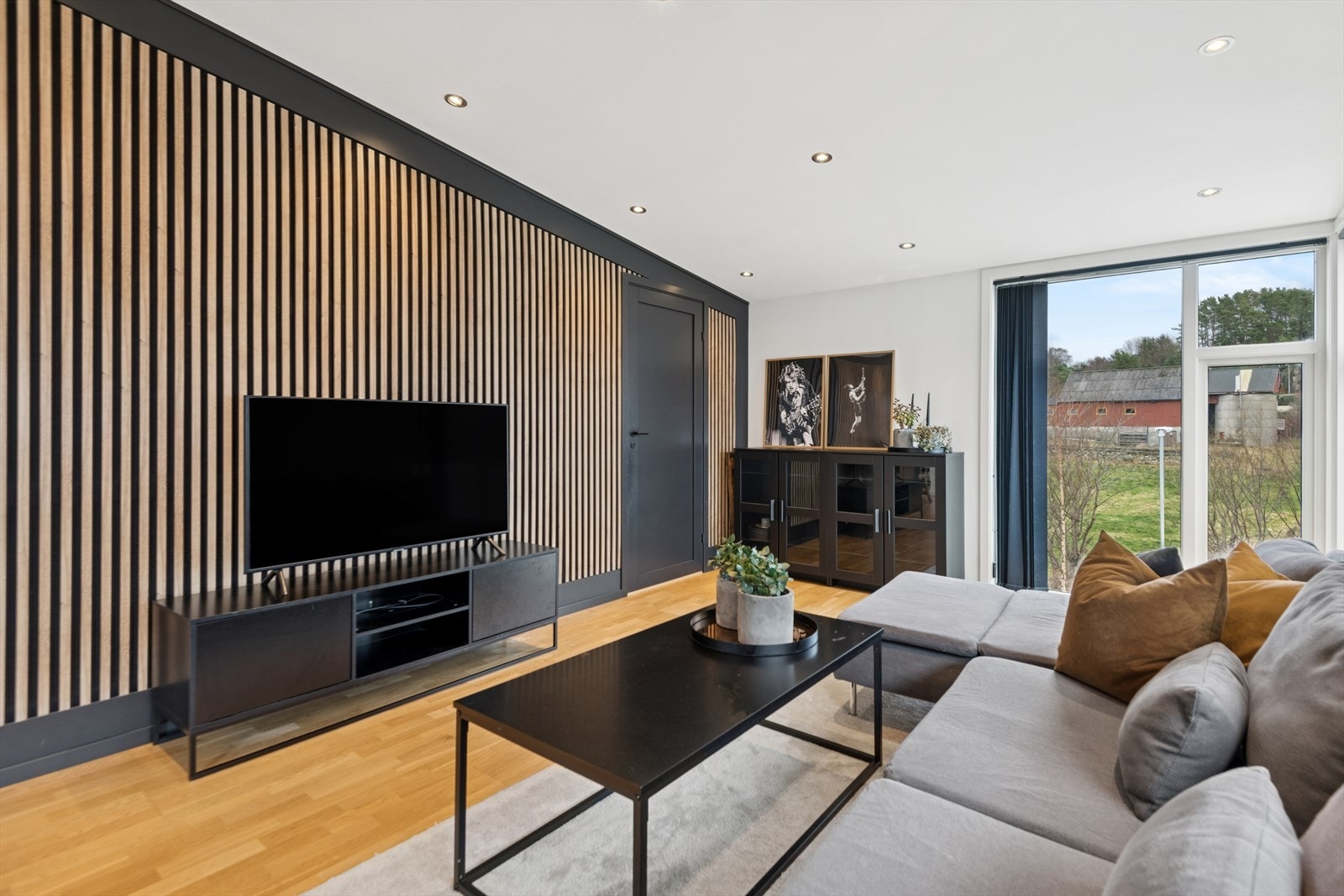 Store vindusflater gir utsyn mot hageområde og slipper inn naturlig lys. Galleribilde