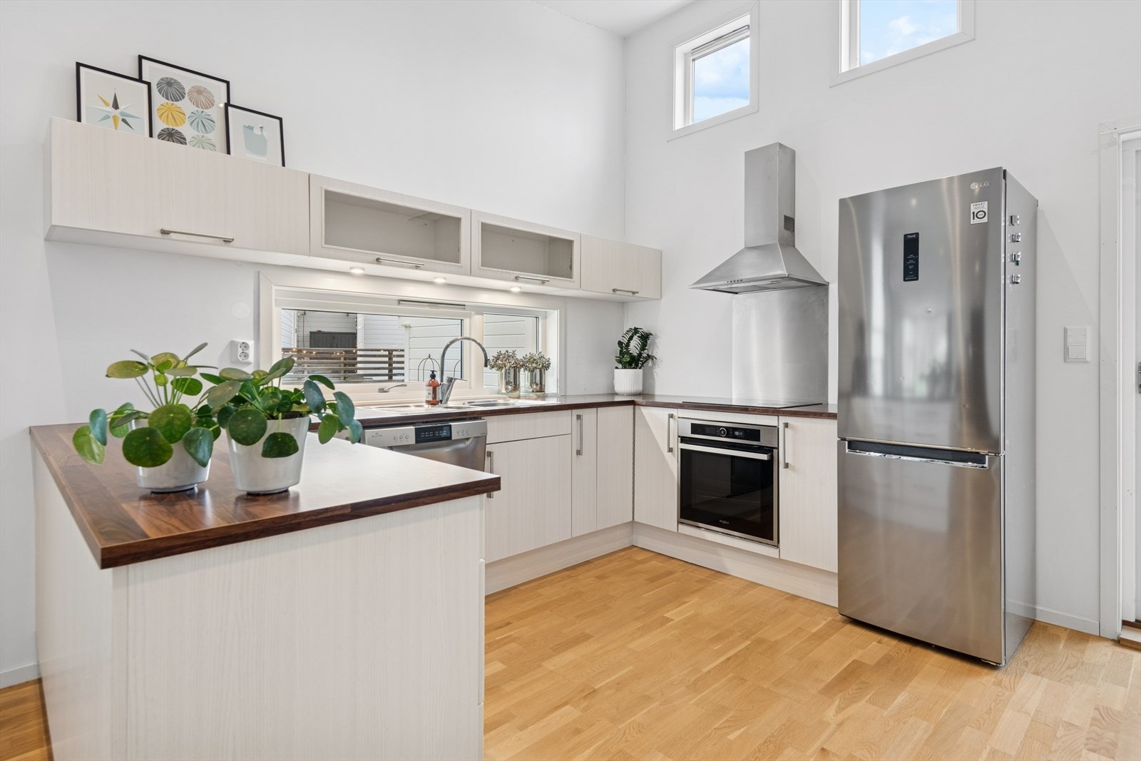 Kjøkkenet har slette fronter og laminatbenkeplate med integrert stekeovn. Galleribilde