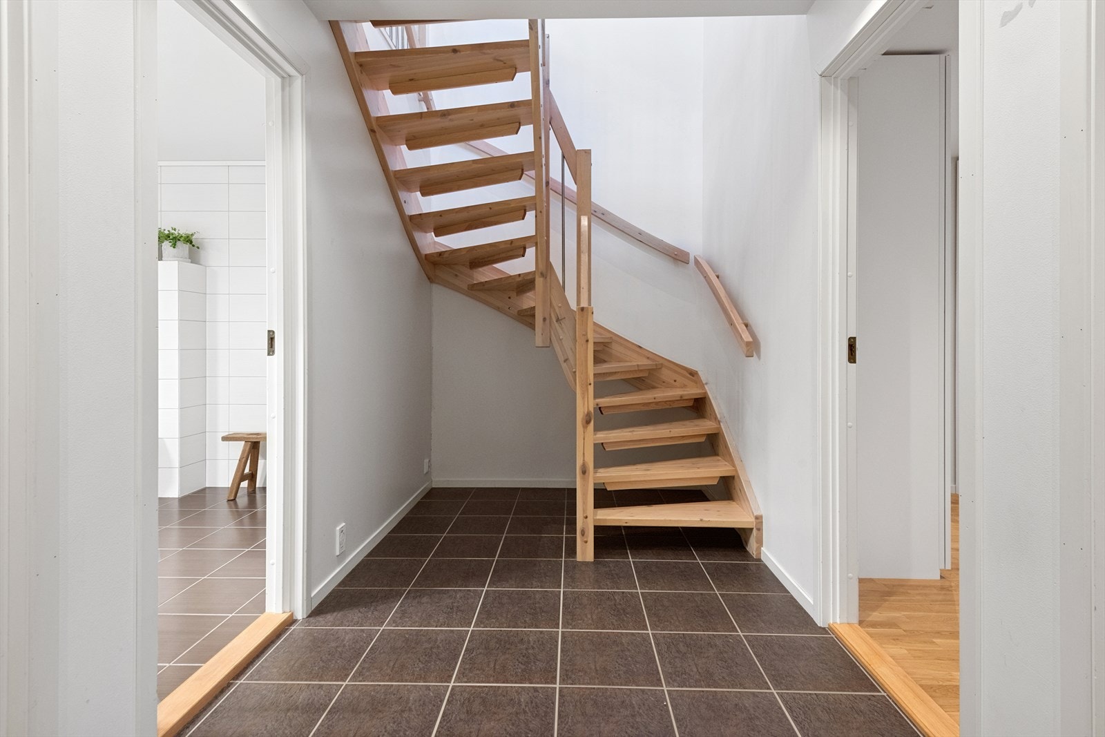 Åpen lakkert trapp gir forbindelse mellom etasjene. Galleribilde