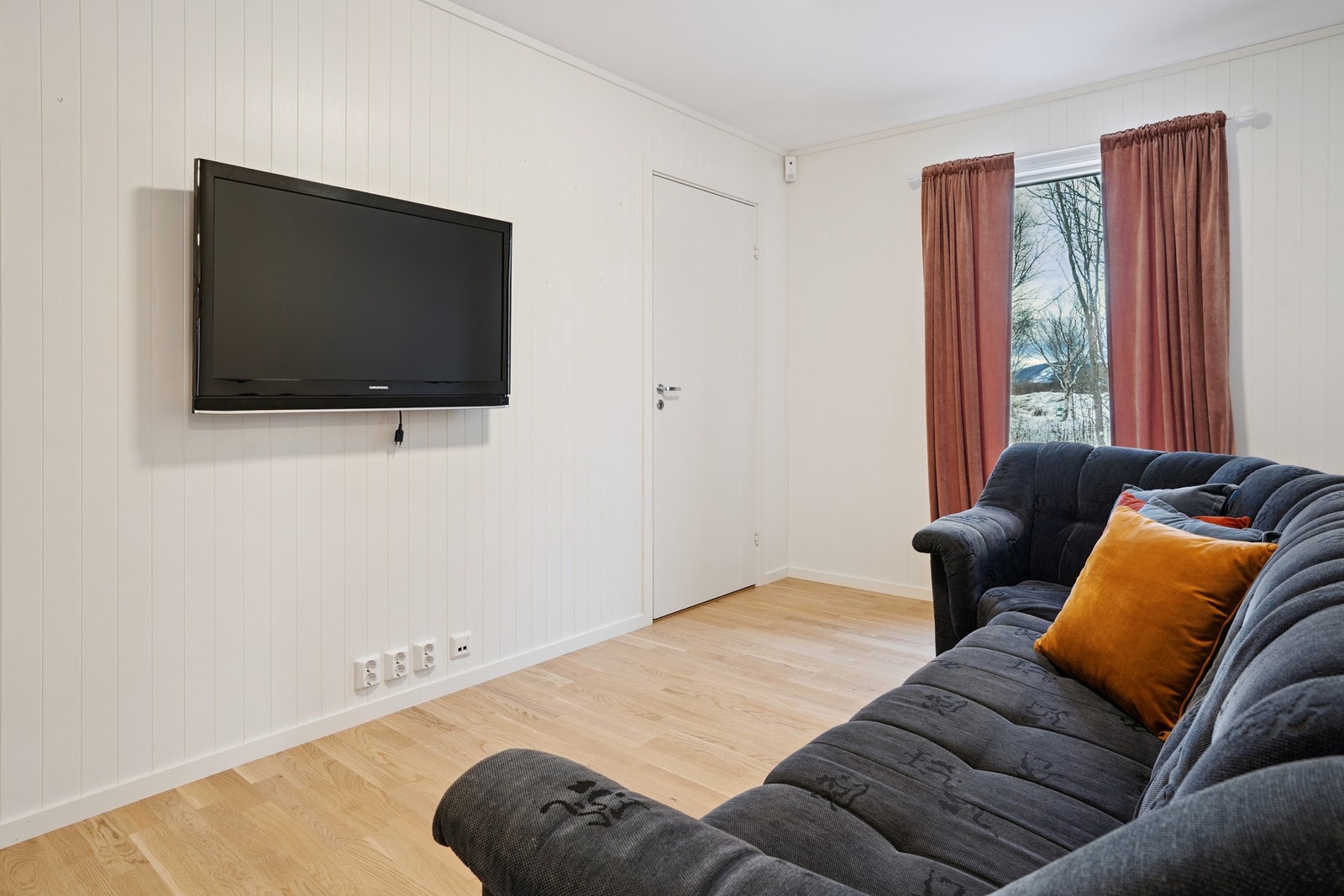 Deler av gangen nede mellom soverommene er praktisk innredet som egen TV-krok. Galleribilde