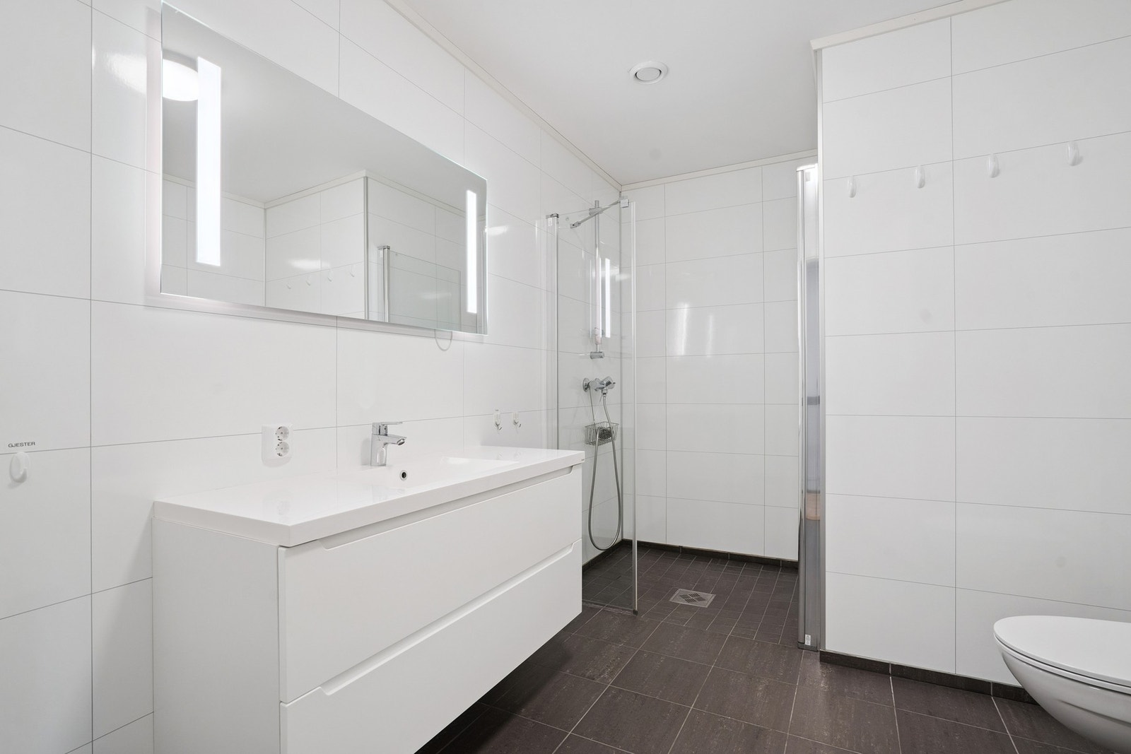 Tidløs bad med våtromsplater på vegger og fliser med vannbåren varme i gulvet. Samt belysning i speilet. Galleribilde