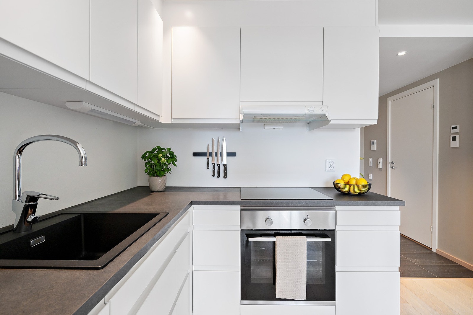 Her finner du en pen laminert benkeplate, komposittkum, induksjonstopp, innebygget stekeovn, oppvaskmaskin og kjøleskap med fryser. Galleribilde