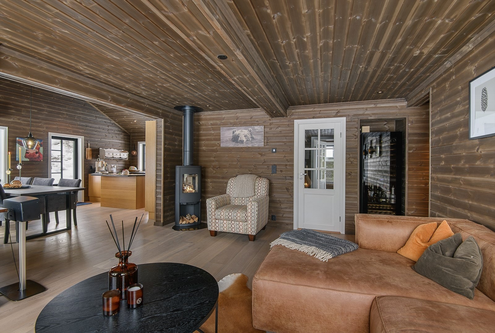 Det er en delvis åpen løsning mellom kjøkken og stue, noe som gir et hyggelig og sosialt oppholdsrom i hytta. Galleribilde