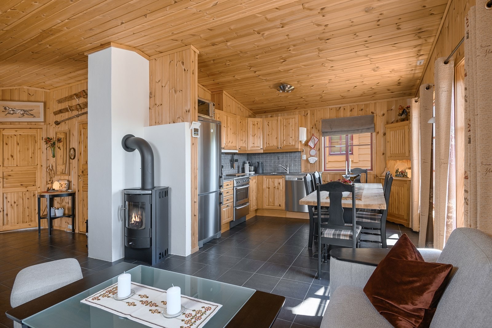 Det er fin kontakt mellom spisestua og sofakroken og hytta har et sosialt og hyggelig oppholdsrom. Galleribilde