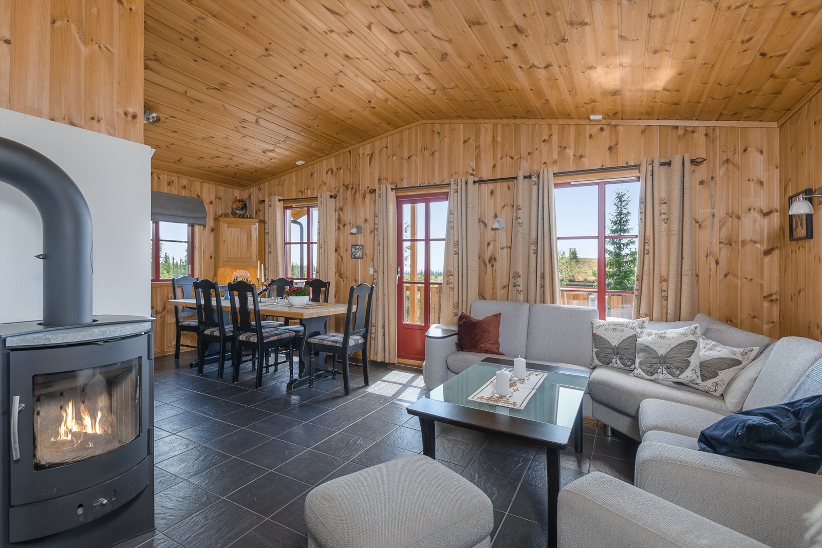 Hytta har koselig stue som ligger i en åpen løsning mot kjøkkenet. En peisovn sørger for ekstra god varme og skaper hyggelig stemning. Galleribilde