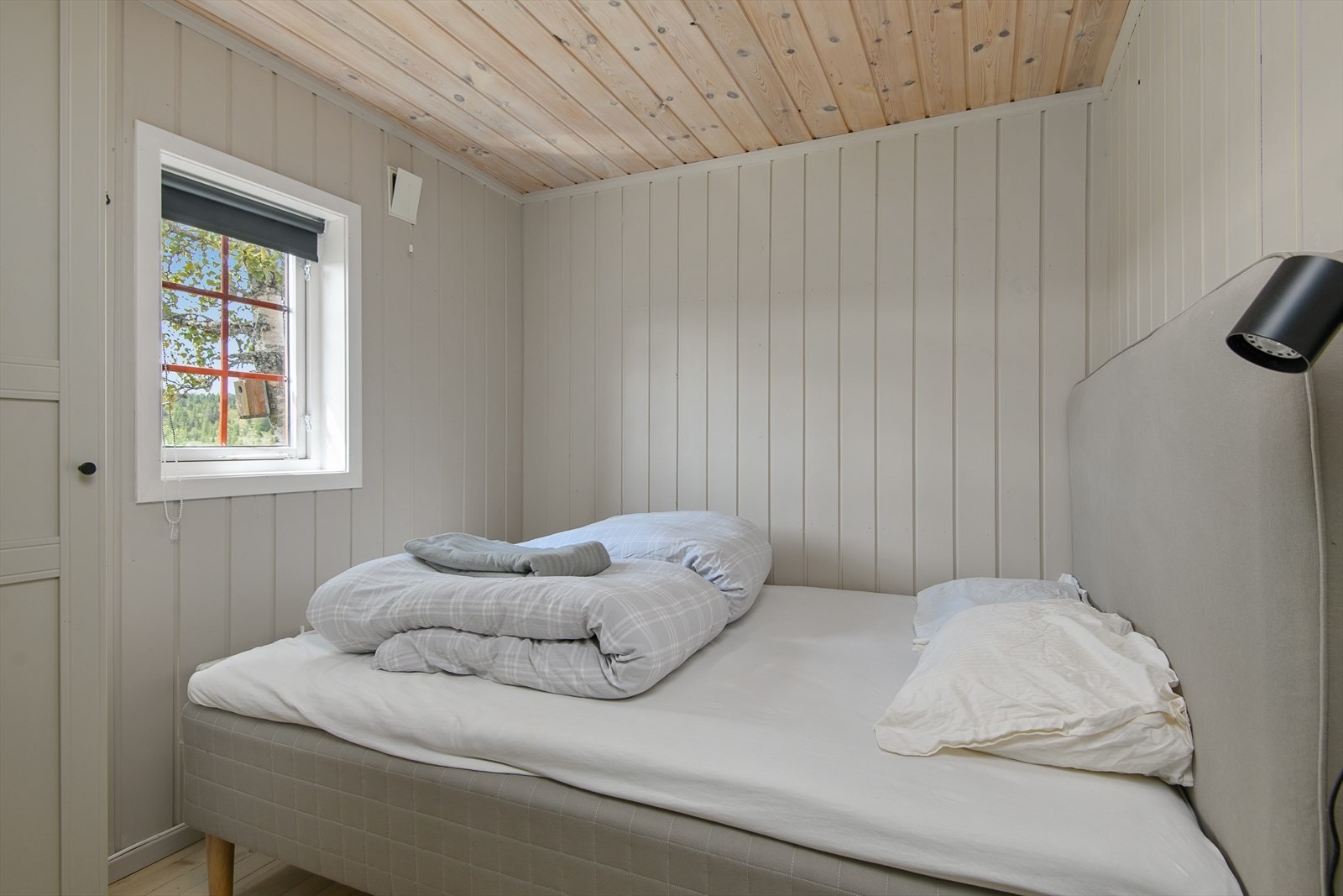 Soverom malt i lyse farger, innredet med dobbeltseng. Galleribilde