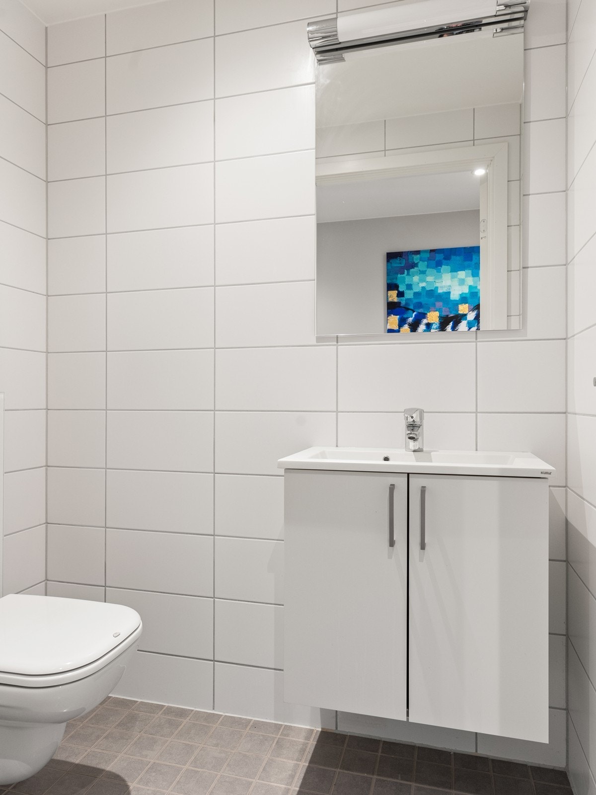 Separat WC-rom med flislagte vegger, varmekabler og servant Galleribilde