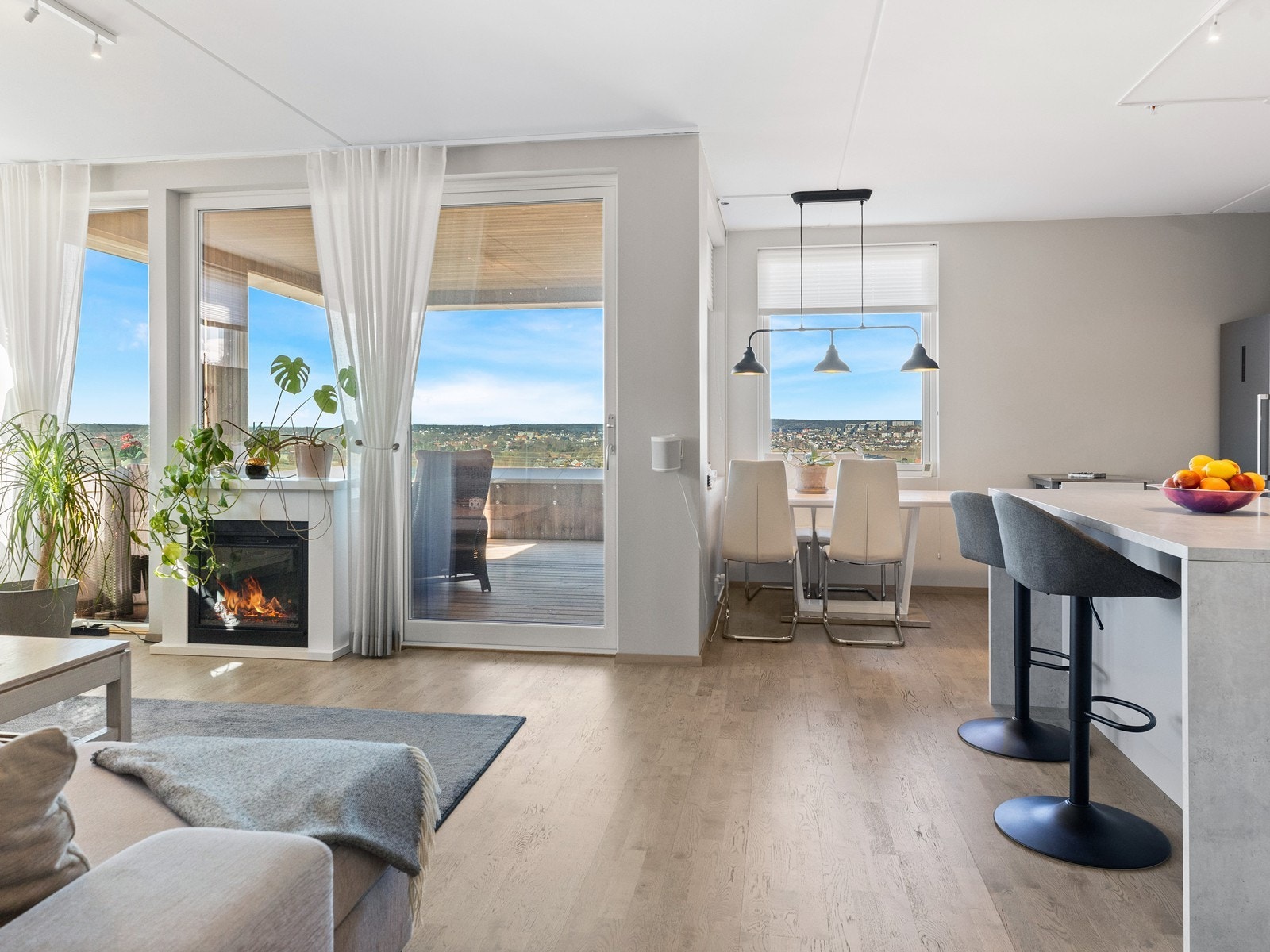 Åpen løsning mellom stue og kjøkken skaper en sosial og innbydende atmosfære Galleribilde