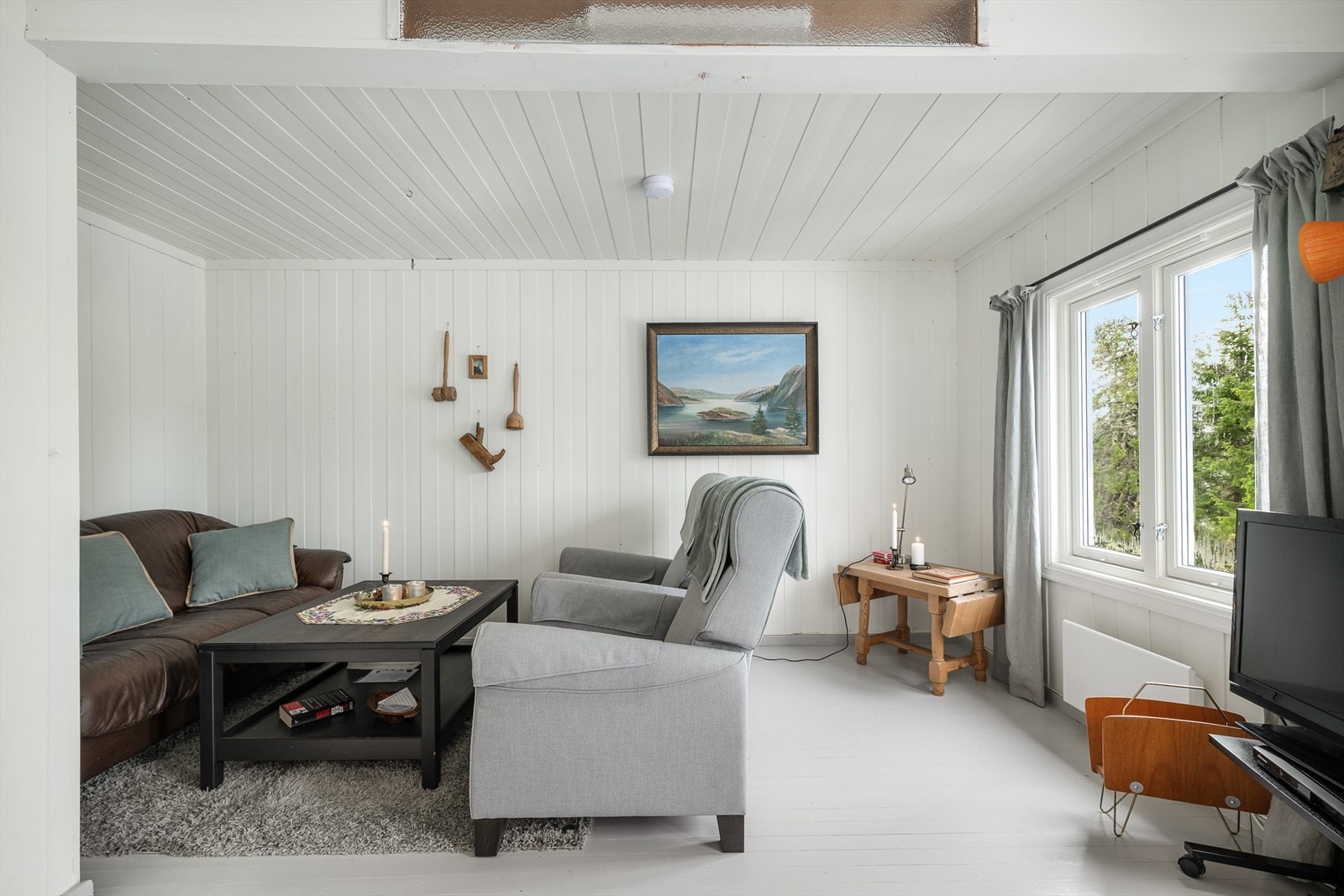 Det kommer fint naturlig lys inn gjennom de store vinduene i stua. Galleribilde