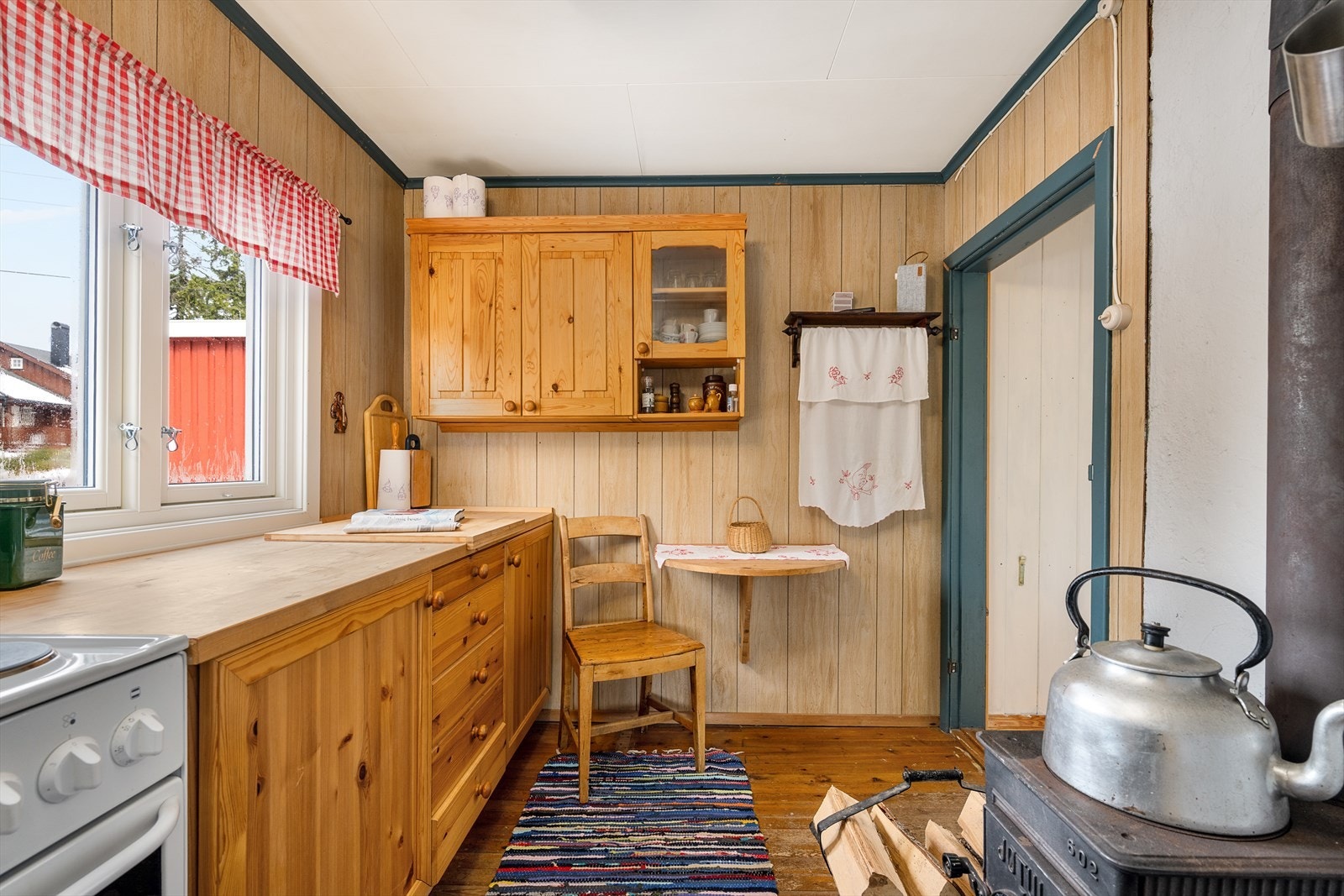 En liten spiseplass på kjøkkenet. Vedovn for god varme. Galleribilde