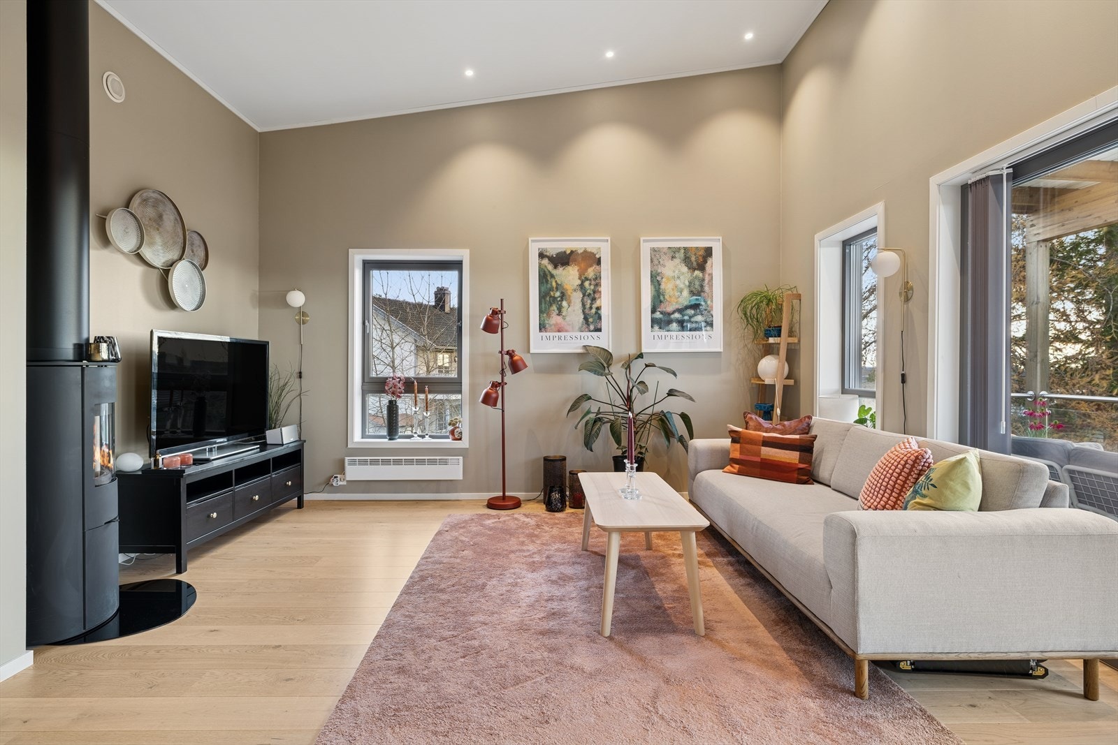 Den gode takhøyden i stuen gjør rommet luftig og lyst. Det er downlights i taket. Galleribilde