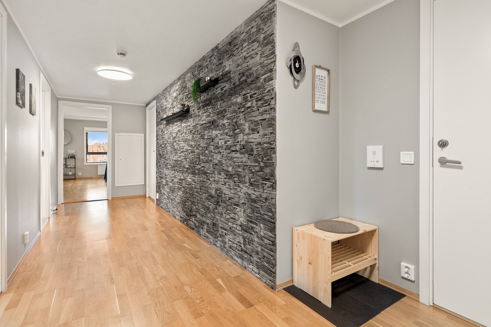 Det er også god plass til flere oppbevaringsløsninger i gangen ved behov. Dekorveggen i stein lager en kul kontrast til de ellers slette veggflatene. Galleribilde