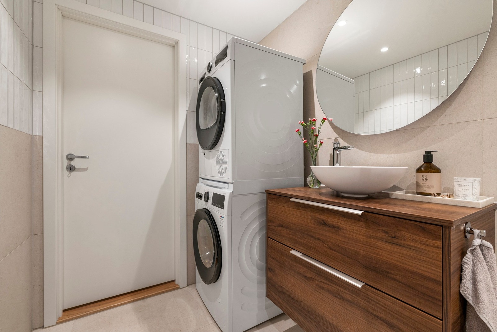 Baderomsinnredningen er bestående av skuffeseksjon med toppmontert skålservant, speil, vegghengt klosett, dusjhjørne med svingbar glassdør og opplegg for vaskemaskin Galleribilde