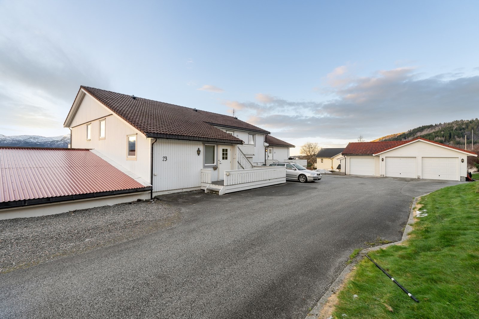 Eiendommen har en praktisk asfaltert adkomstvei med god plass til parkering i medfølgende garasje. Ny hovedytterdør gir et moderne preg til inngangspartiet. Galleribilde