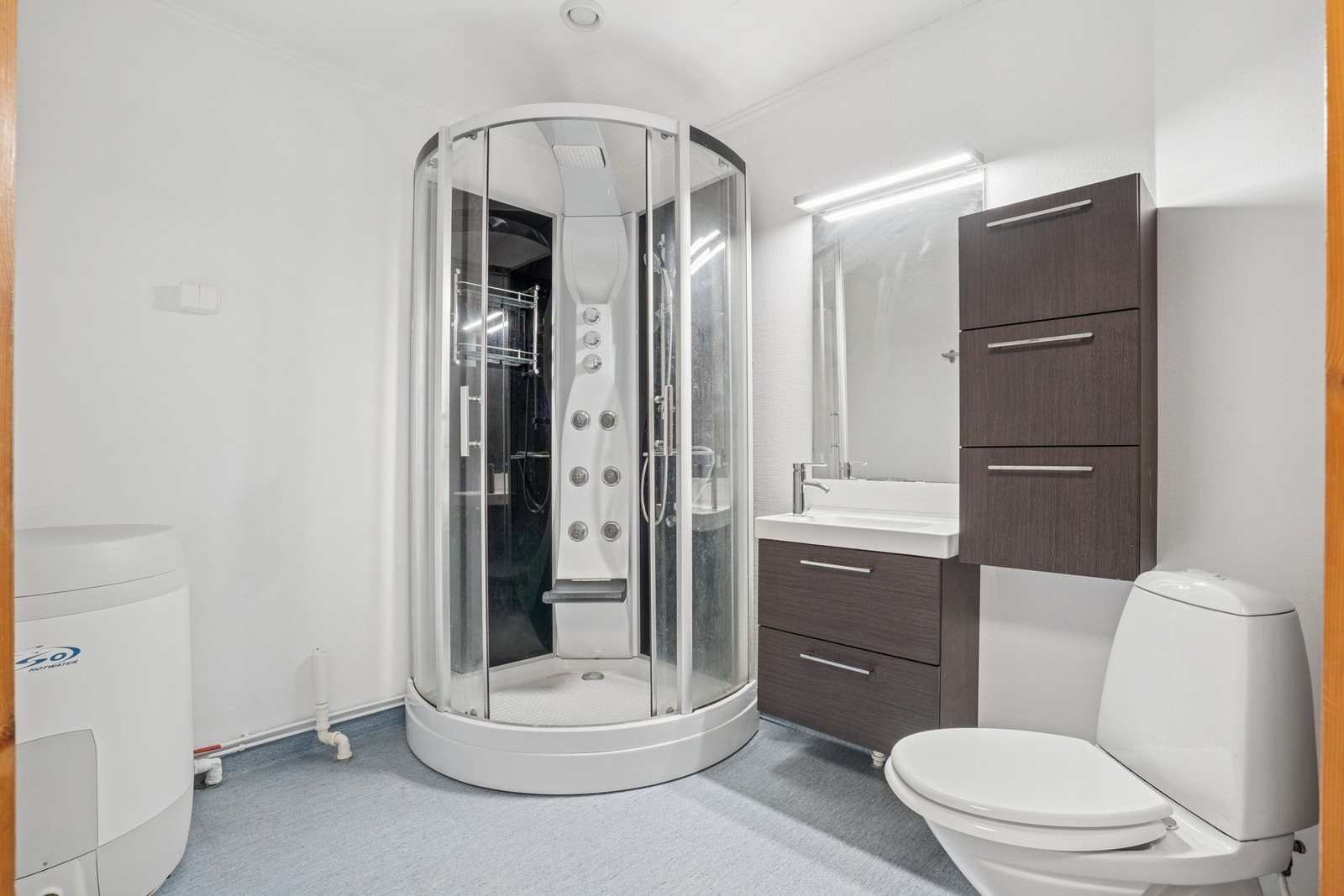 Badet er utstyrt med toalett, dusjkabinett og servantinnredning med speil . Galleribilde