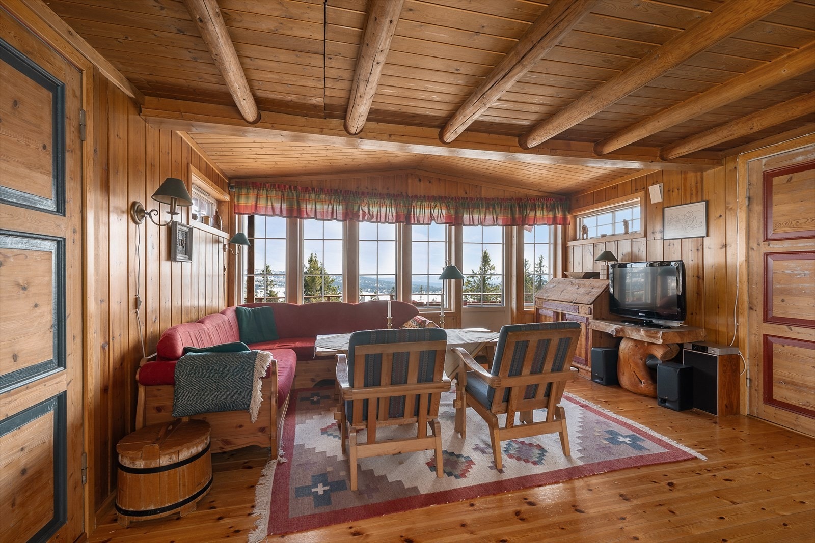 De mange vinduene på stuen gjør at den flotte utsikten også kan nytes fra sofakroken, samt at de gir godt med lys til rommet. Galleribilde