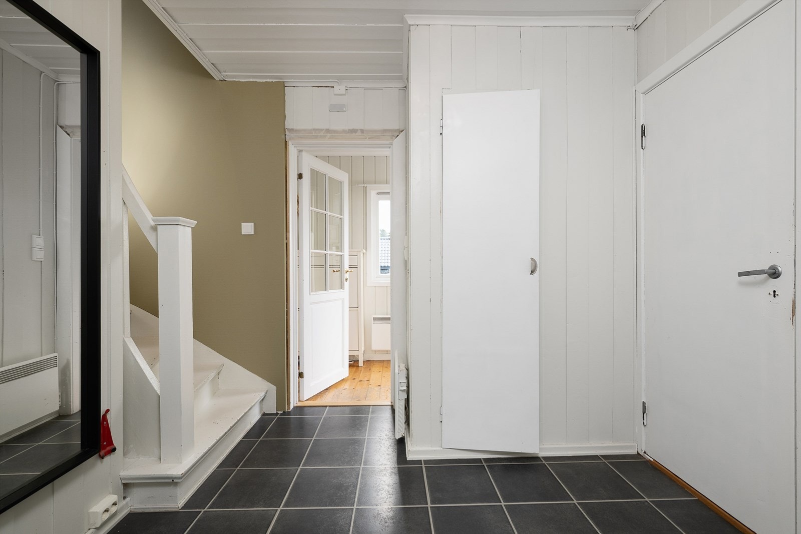 Det er inngang via et lite vindfang og inn i gangen i 1. etasje. Galleribilde