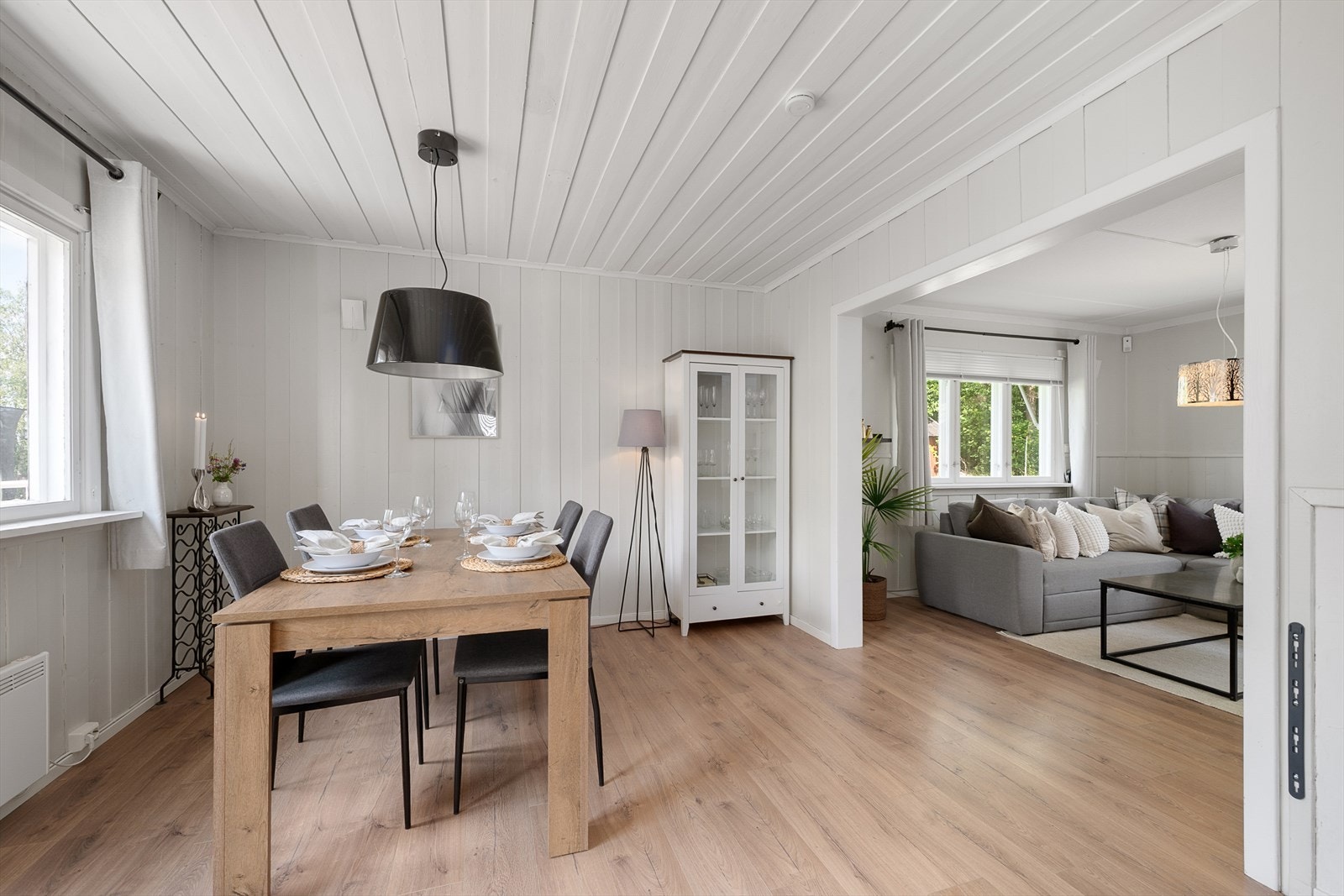 Forholdsvis åpen løsning mellom spisestue og stue. Malt panel på tak og vegger. Galleribilde